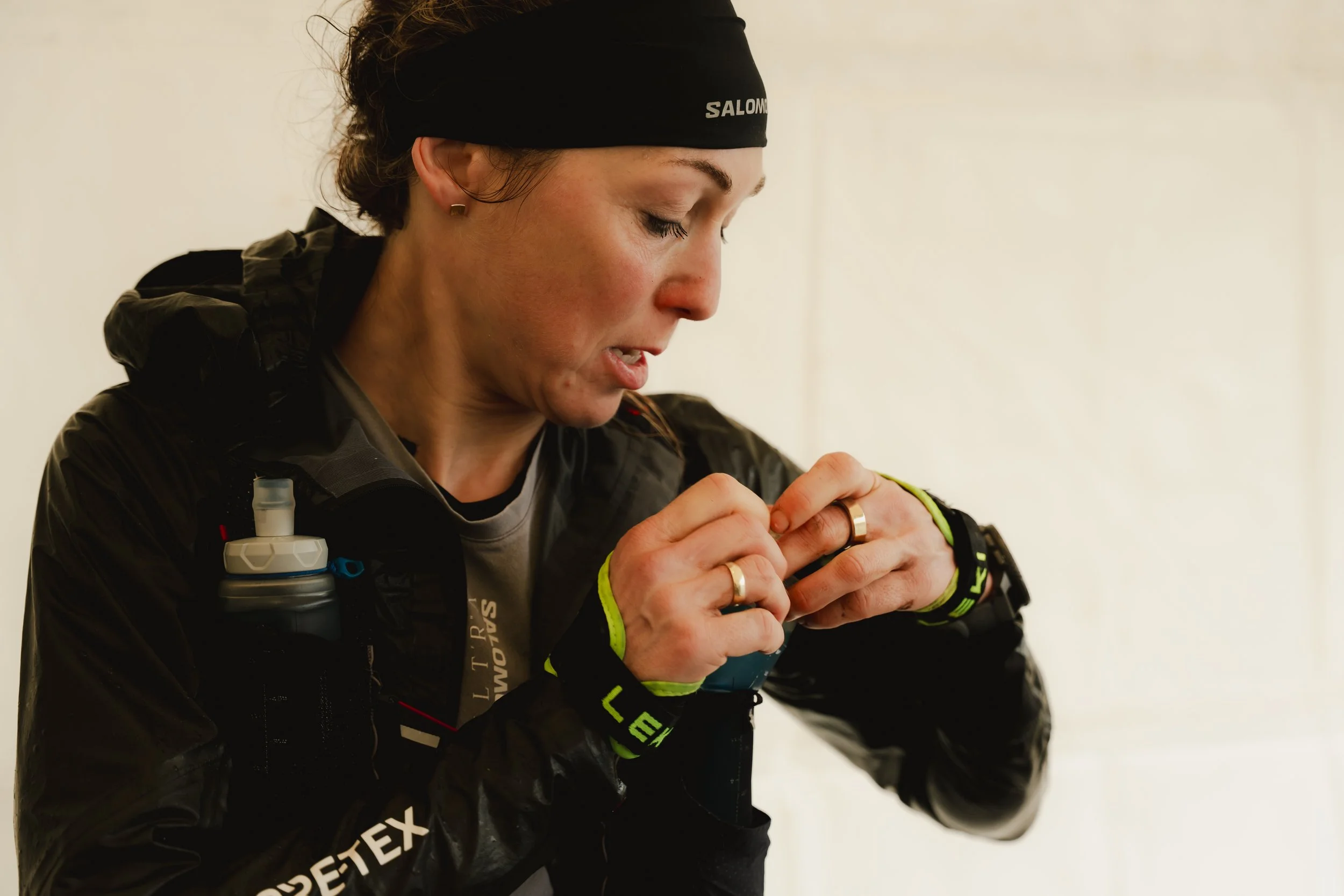 Eine Frau in Sportbekleidung überprüft eine Uhr am Handgelenk.