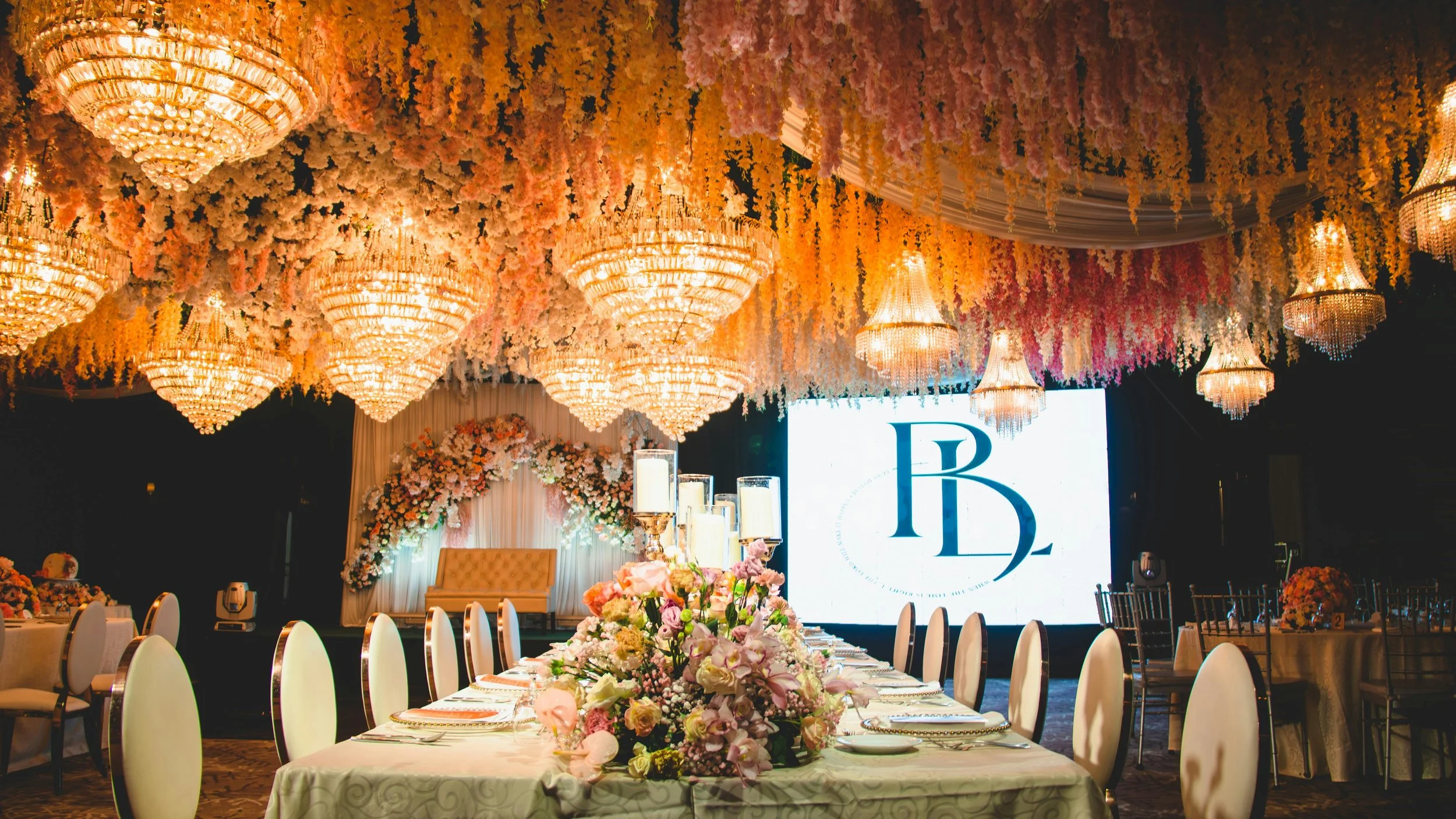 Indoor wedding ceremony with white chairs and floral arch coordinated by Regal Rendezvous wedding planner Baltimore DMV