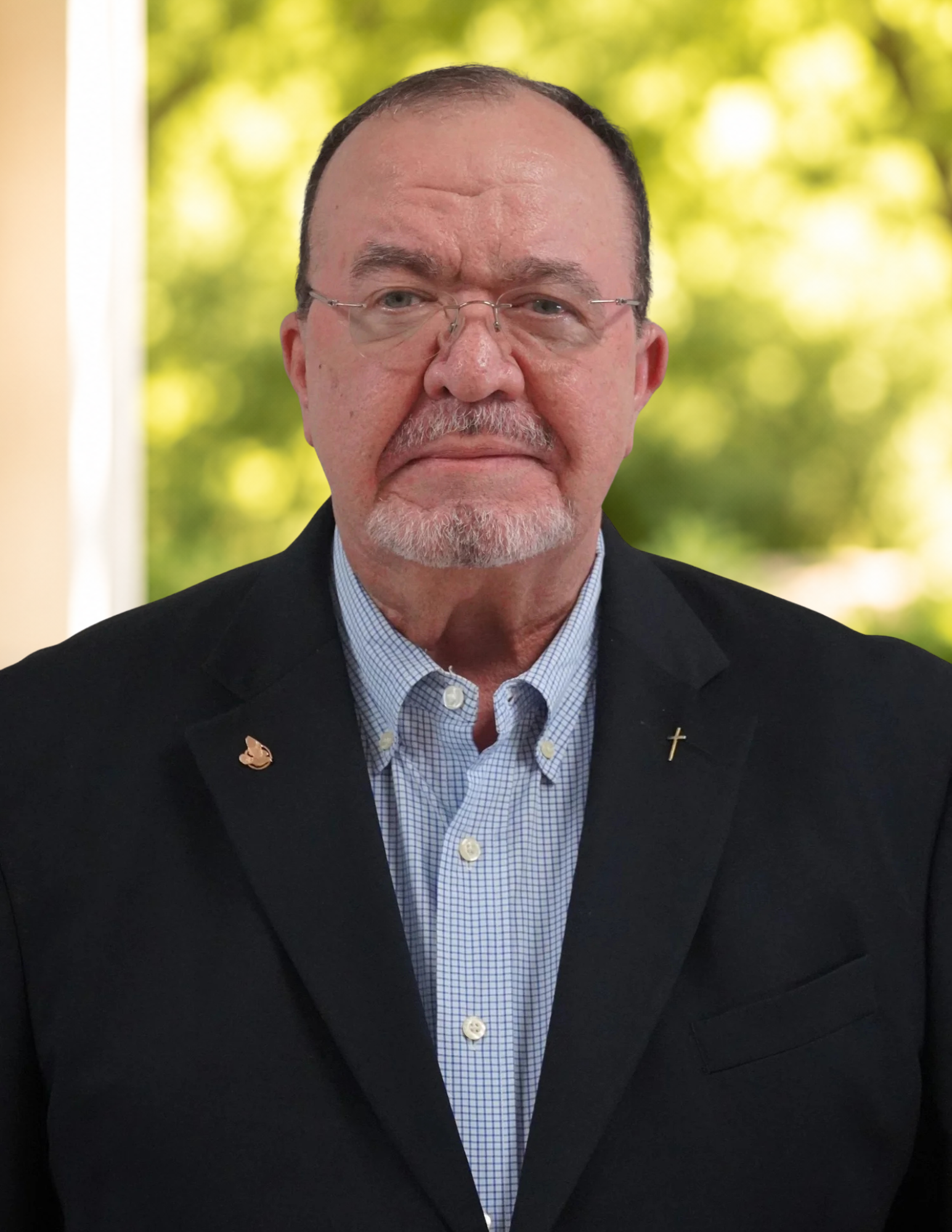 Elderly man wearing a suit with a cross pin