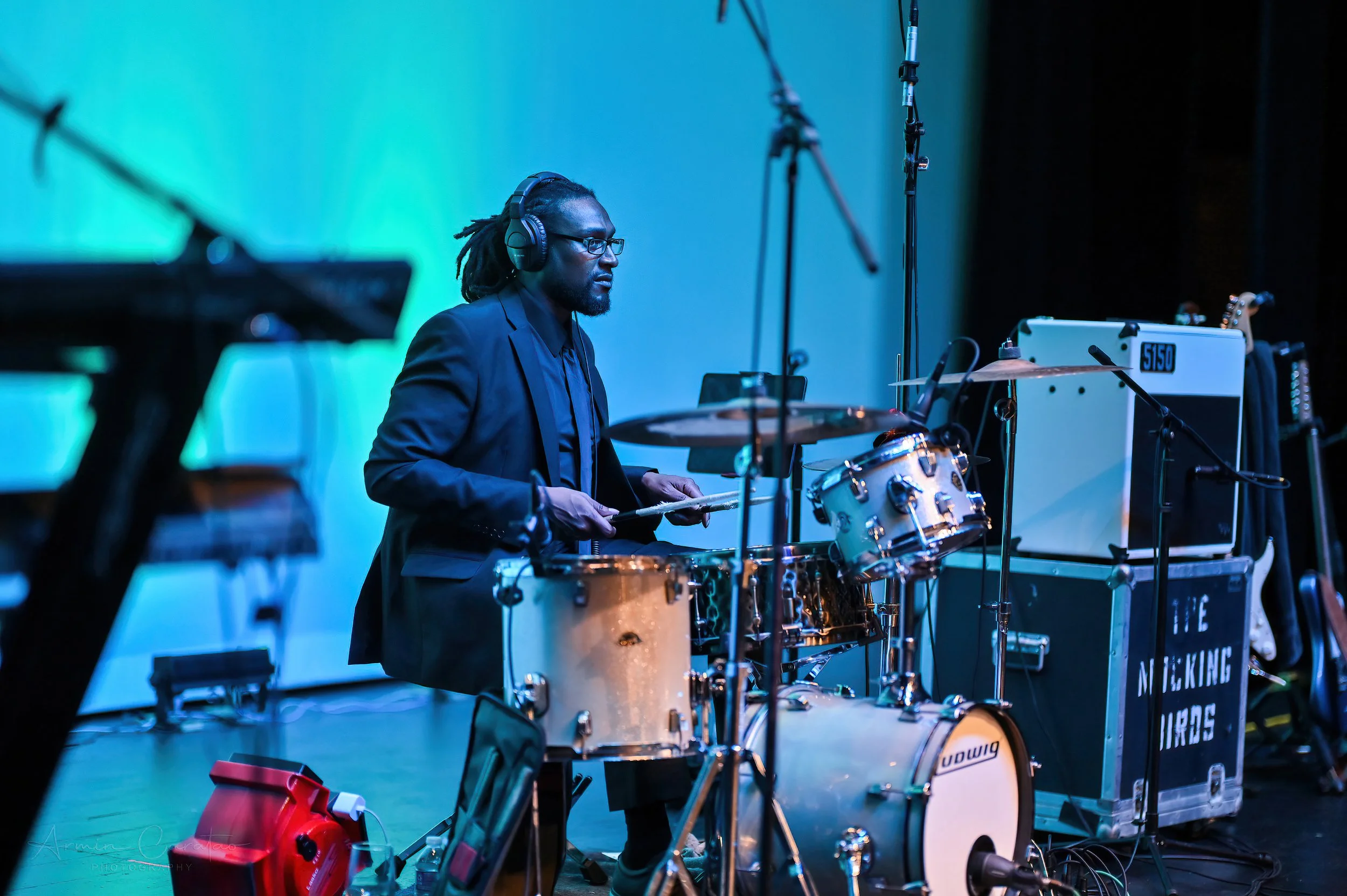 Musician playing drums on stage with headphones