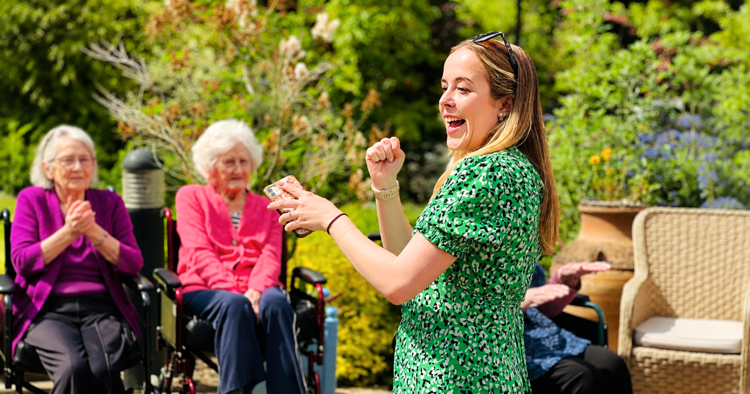 Sophie from Stand Out Performing Arts leading a Care Home Choir singing session outdoors with elderly residents in Bristol