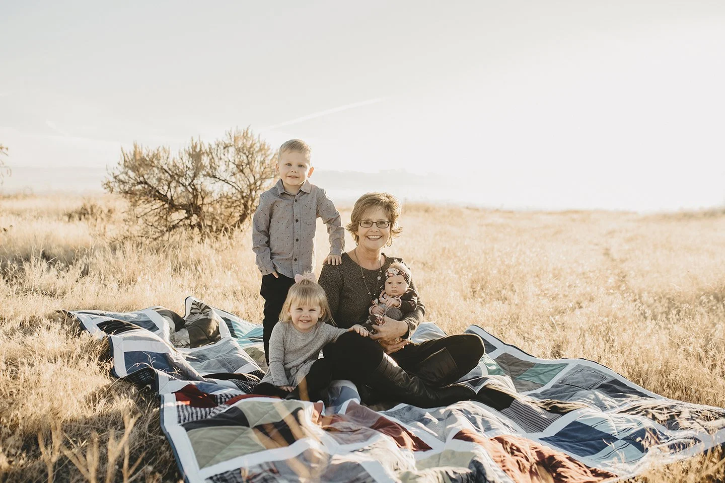 A heartfelt portrait honoring her late husband, with grandma and her grandkids sitting on a quilt in Zillah, WA
