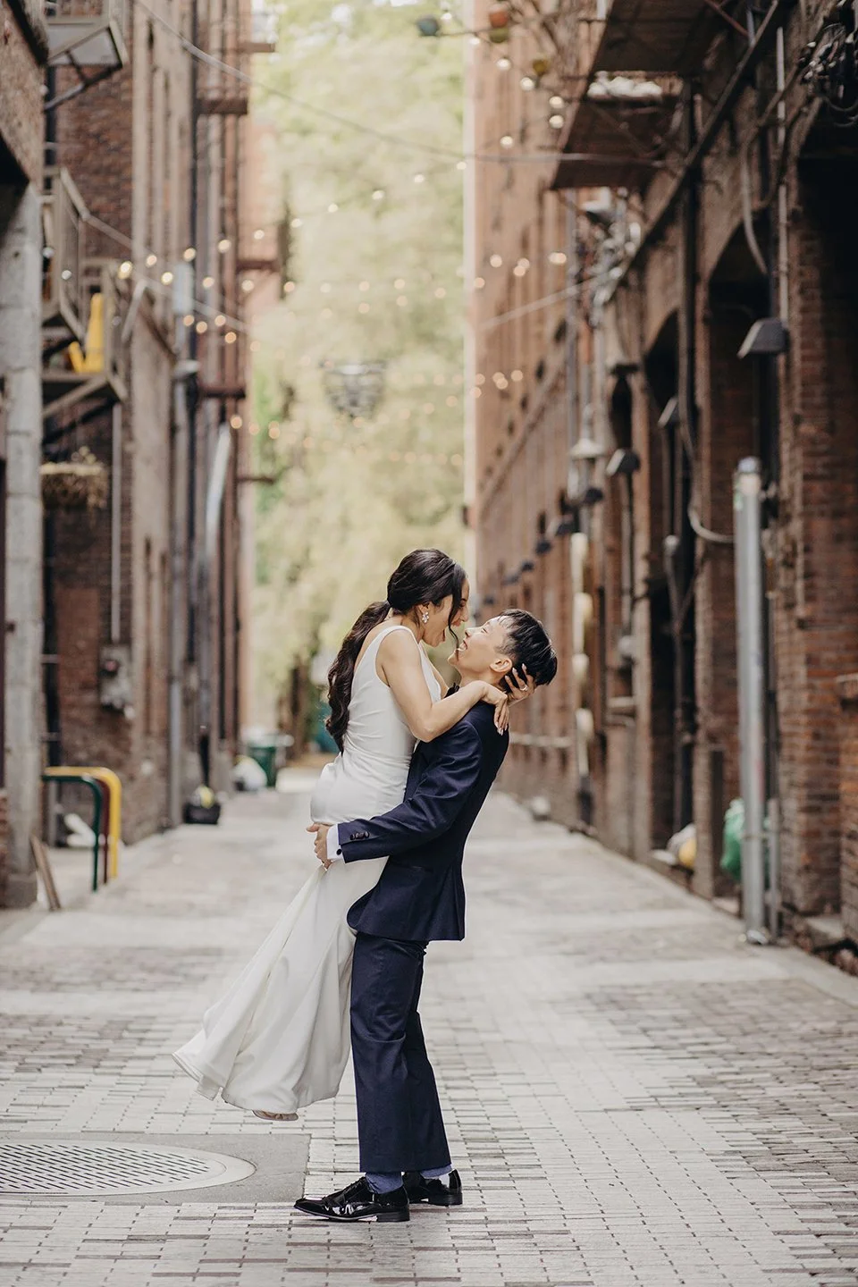 Emotional groom picking up his bride in the air at Pionner Square, a destination wedding in Seattle, WA documented by Ob Cruz Photography