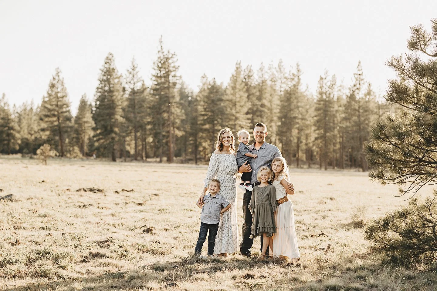 A summer forest-style family session in Goldendale, WA with glowing light and tall pines.
