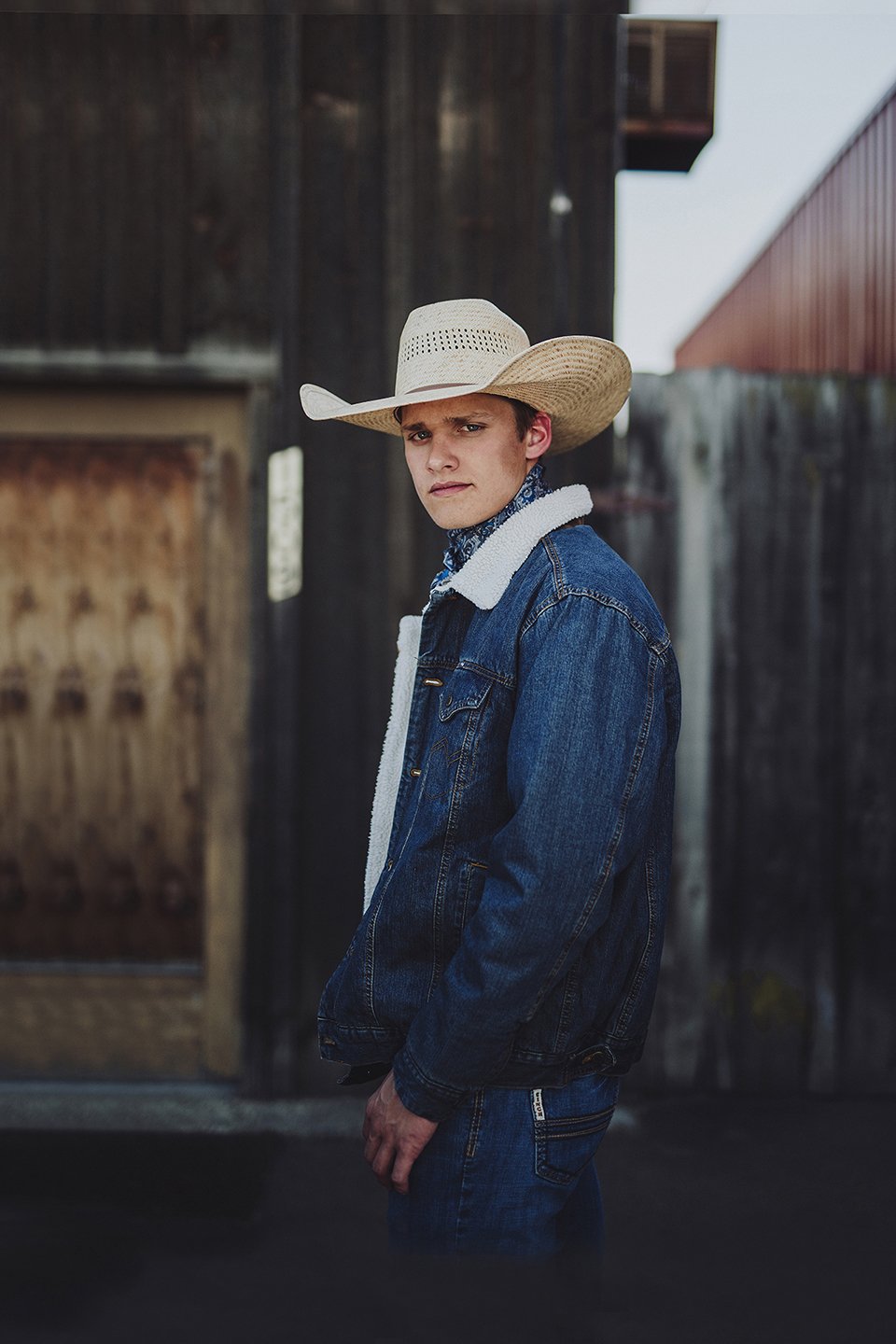 Western senior portraits with an old barn backdrop for a rustic, authentic feel in Sunnyside, WA