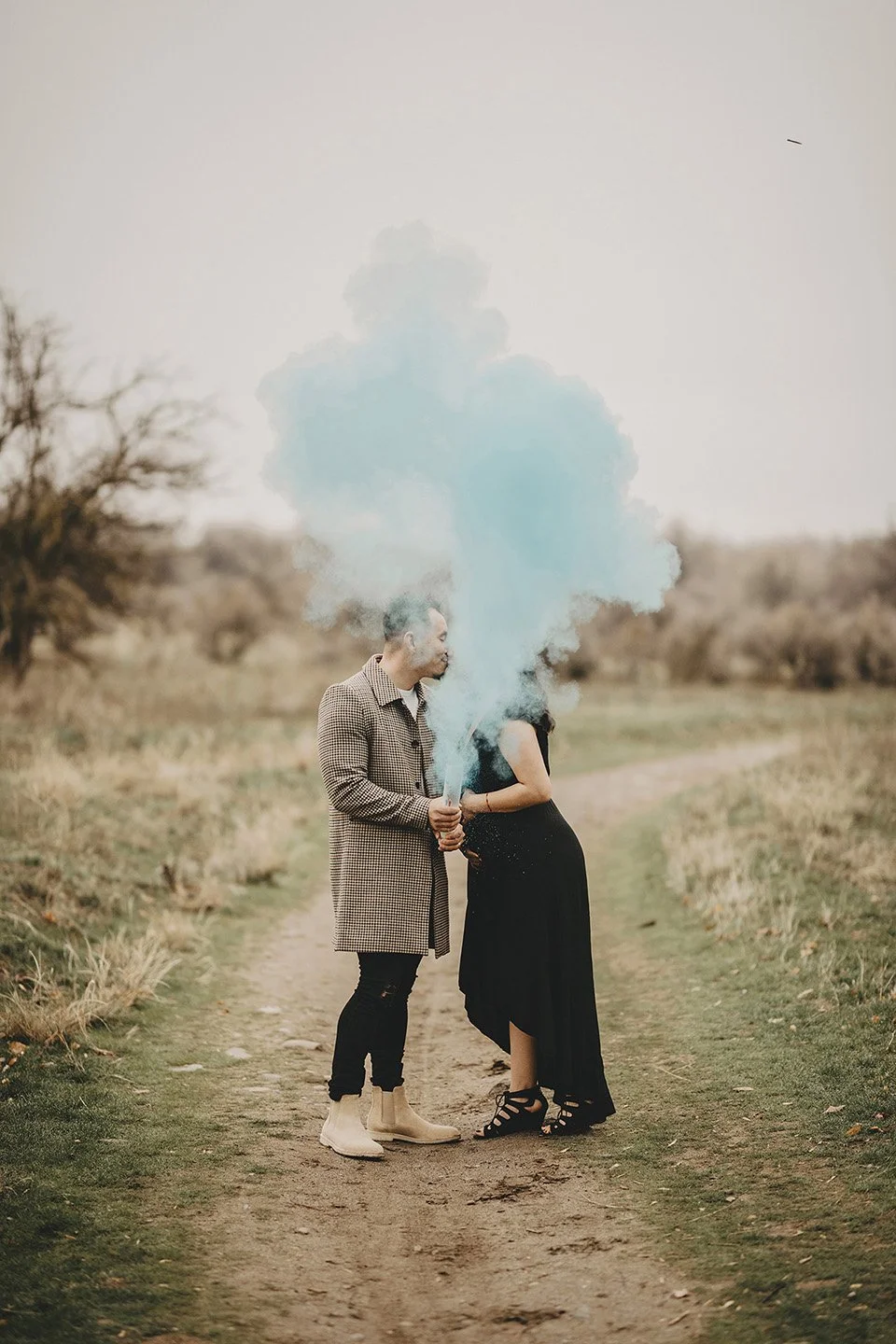 A joyful blue-smoke gender reveal in Richland, where the expecting couple celebrates their baby boy with bright smiles and warm connection.