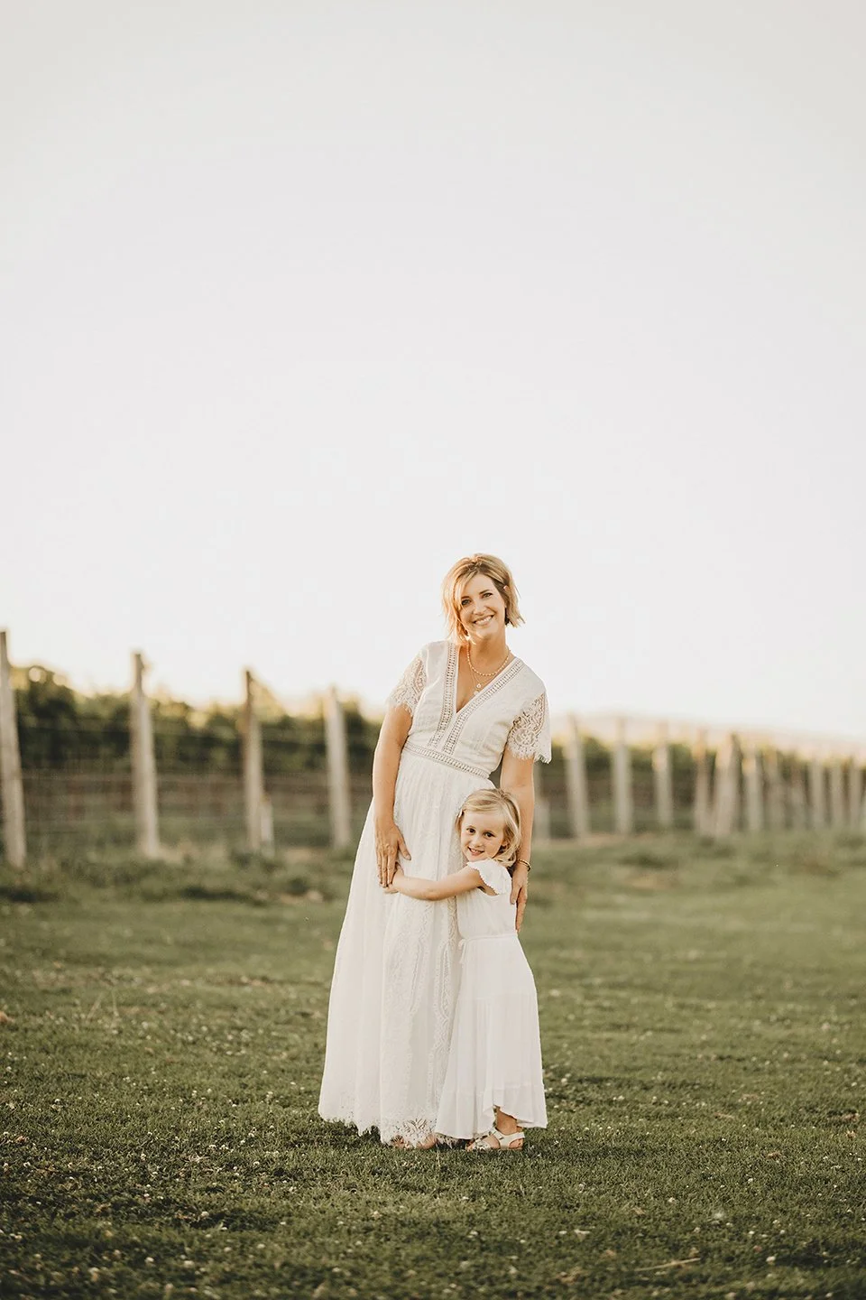 Mother and daughter at their ranch in Prosser, WA during sunset — soft Hampton-style tones, warm light, and a sweet, natural moment between them.