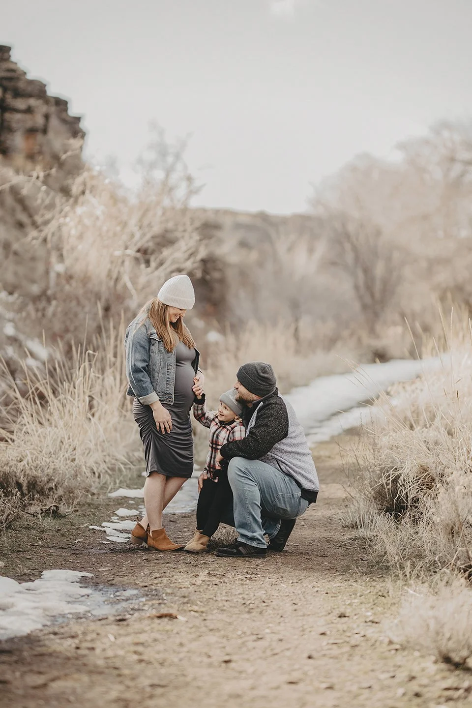 A sweet winter family moment in Yakima, where big sister rests her hand on mum’s belly while dad holds her close — a tender connection wrapped in soft seasonal light.