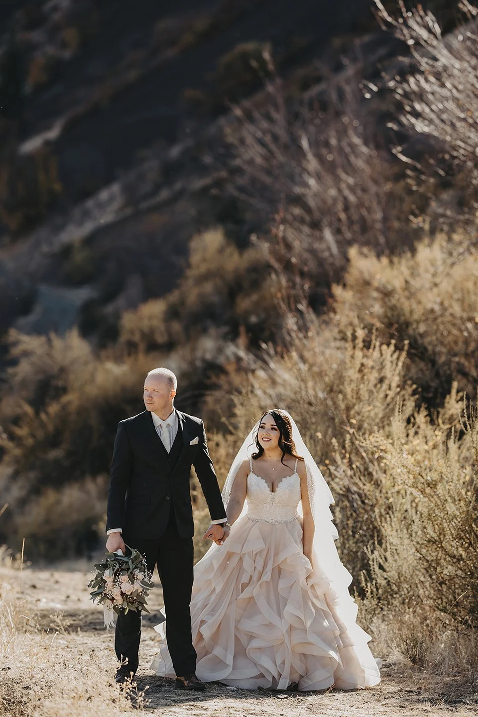Vertical full-body shot of bride and groom on the hilltop at American Homestead Naches, WA.