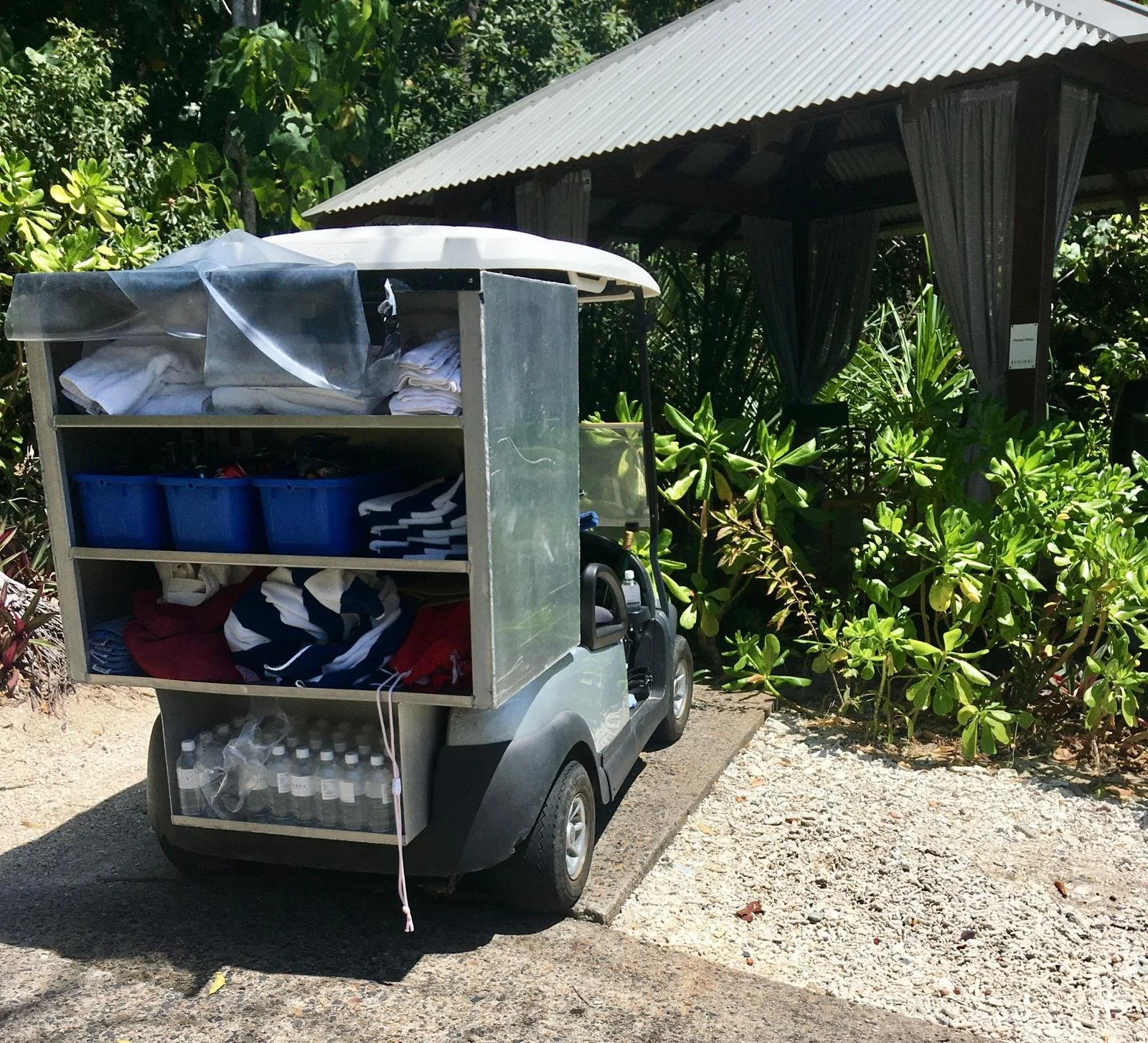 Carrito de golf con sábanas y toallas para restock en housekeeping