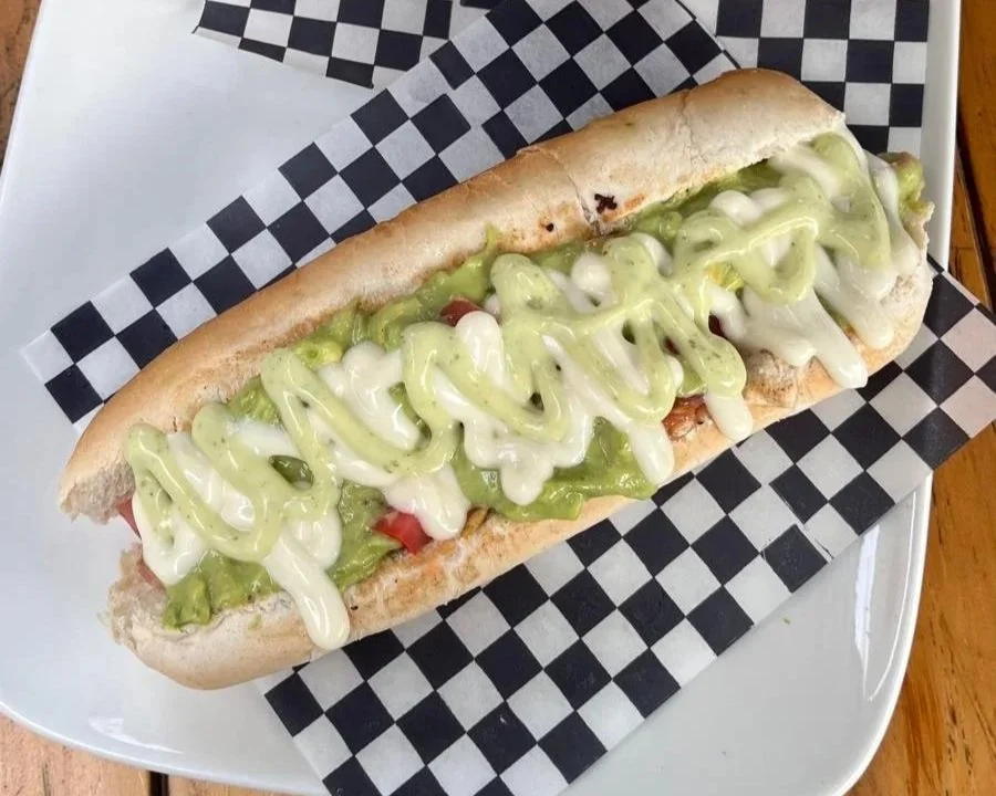 Completo italiano chileno con palta, tomate y mayonesa servido en un local de Santiago