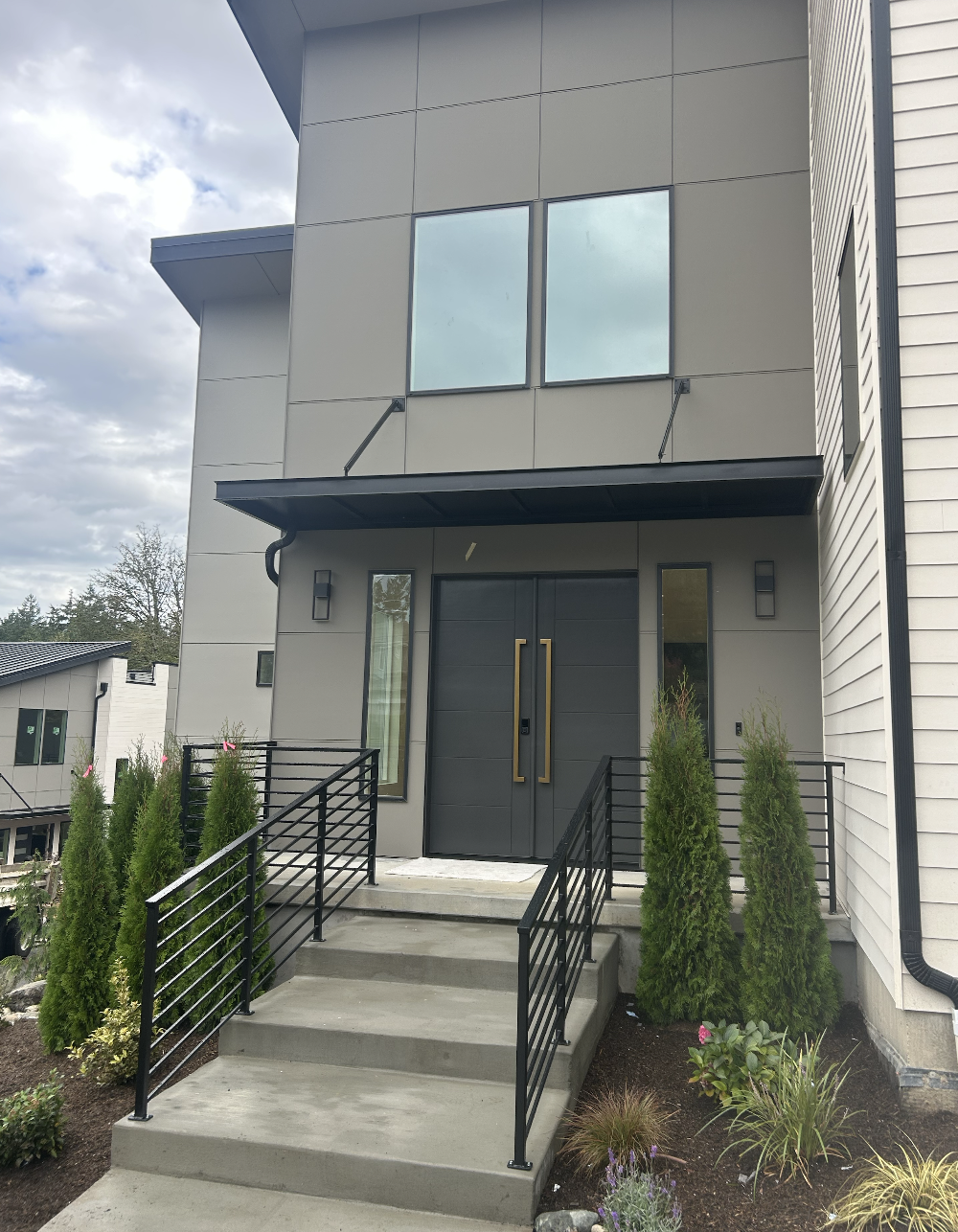 Custom metal staircase with integrated entry canopy fabricated and powder coated in-house