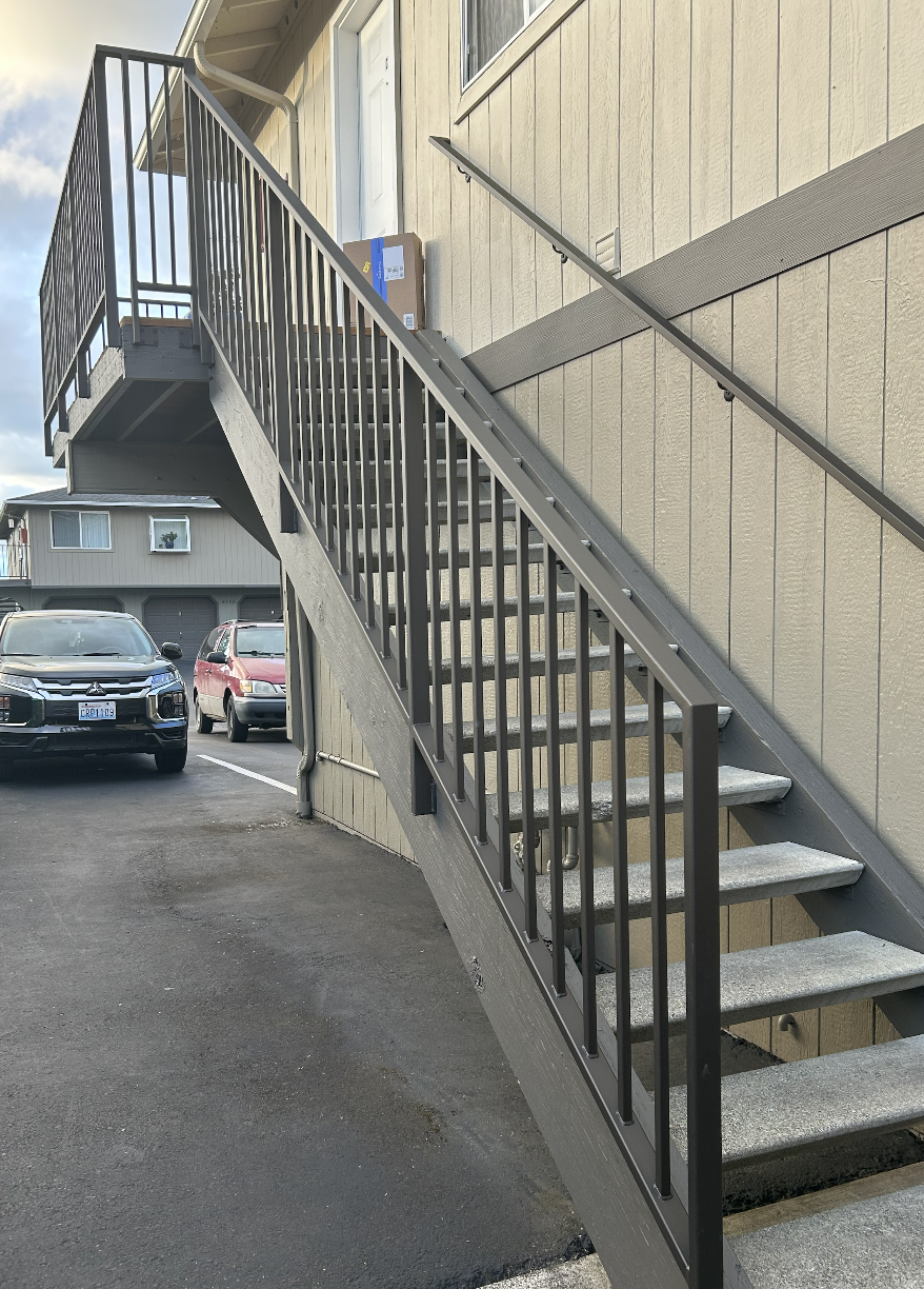 Architectural metal staircase featuring concrete treads and powder-coated metal railings