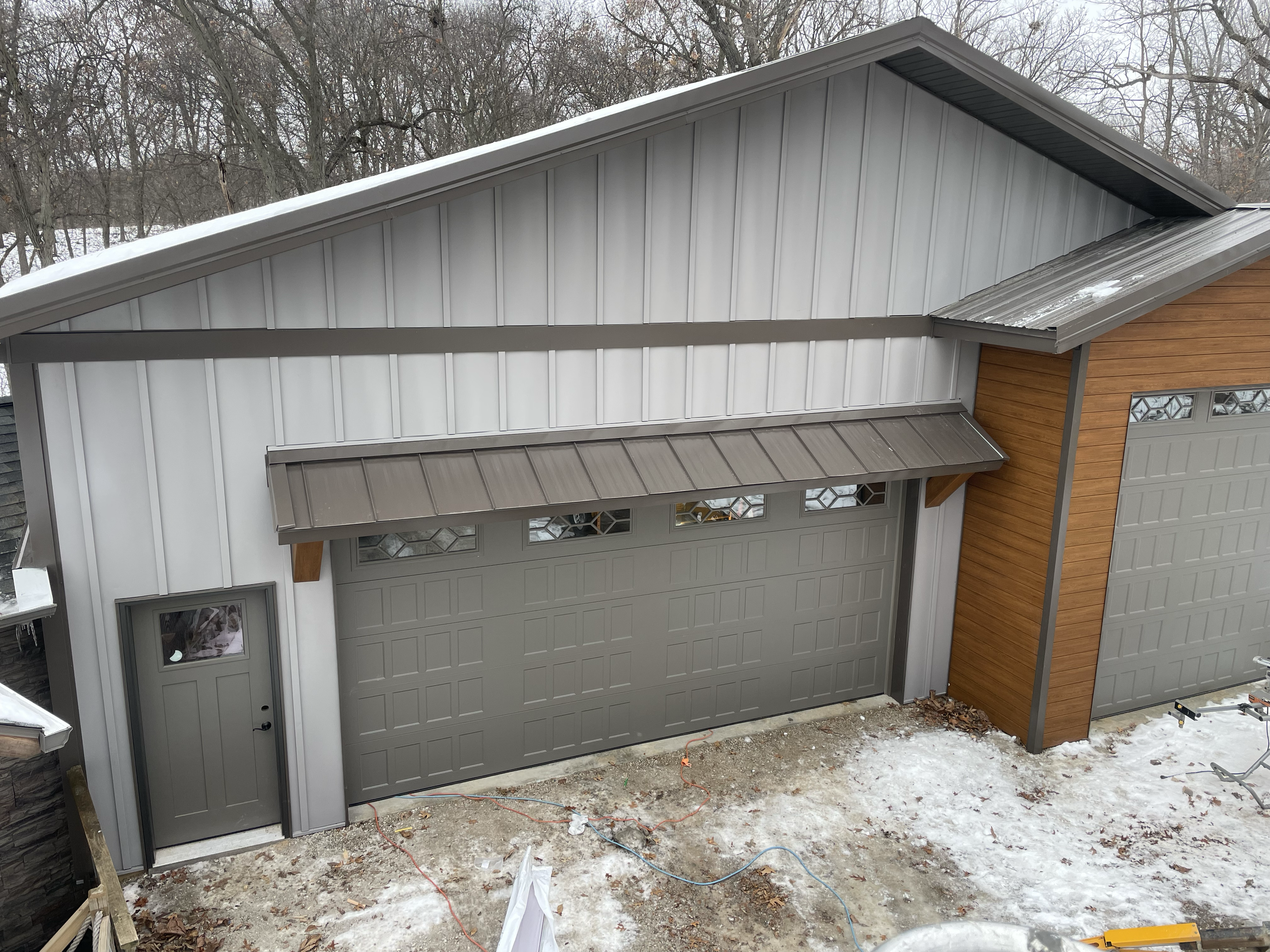 Board and batten steel with standing seam roofing and Cham clad exterior car siding