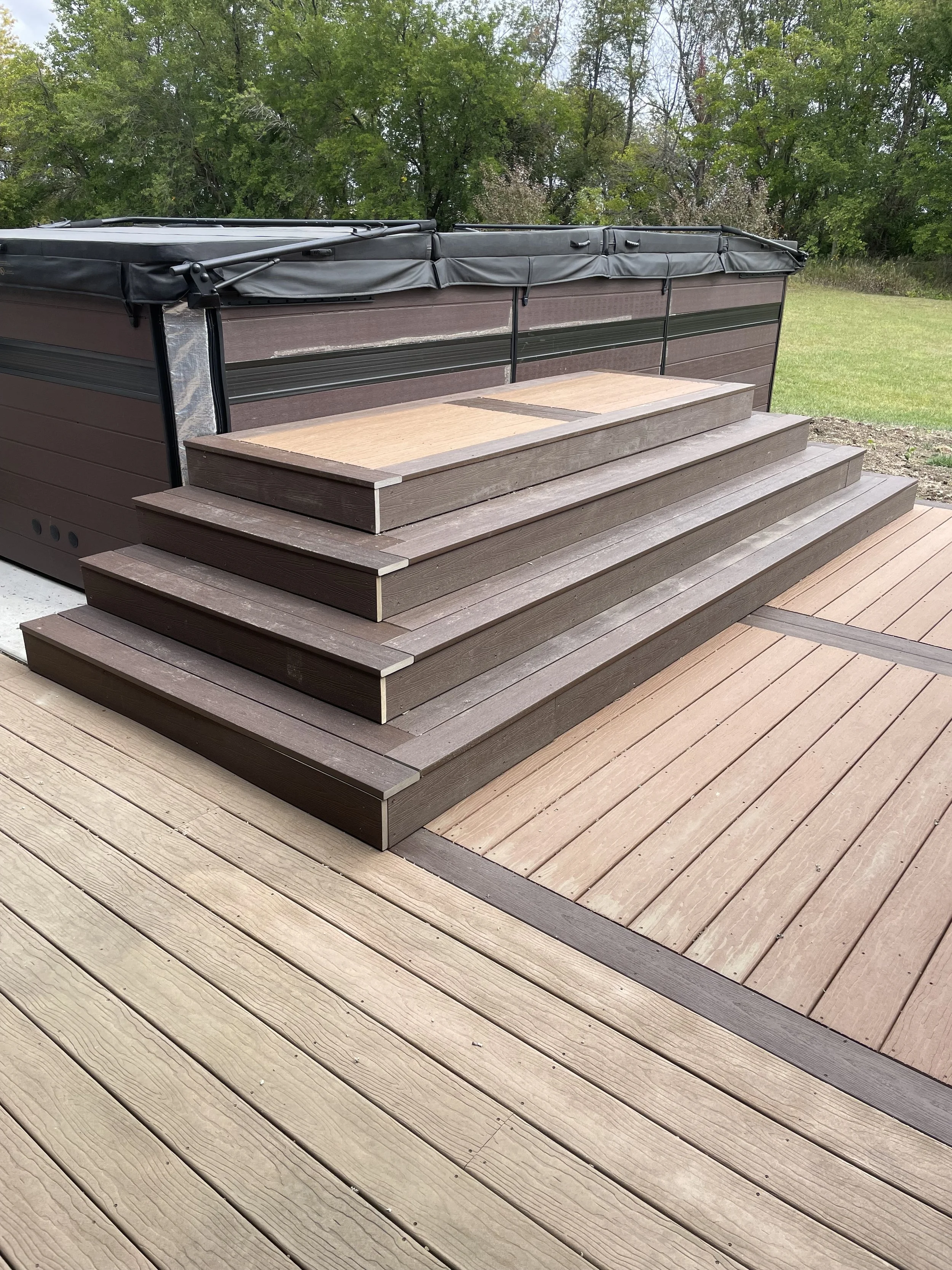 Pyramid style steps up to a hot tub with a new deck. Moisture Shield Decking.
