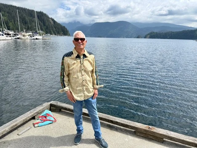 Gregory standing at the end of a dock smiling at the camera