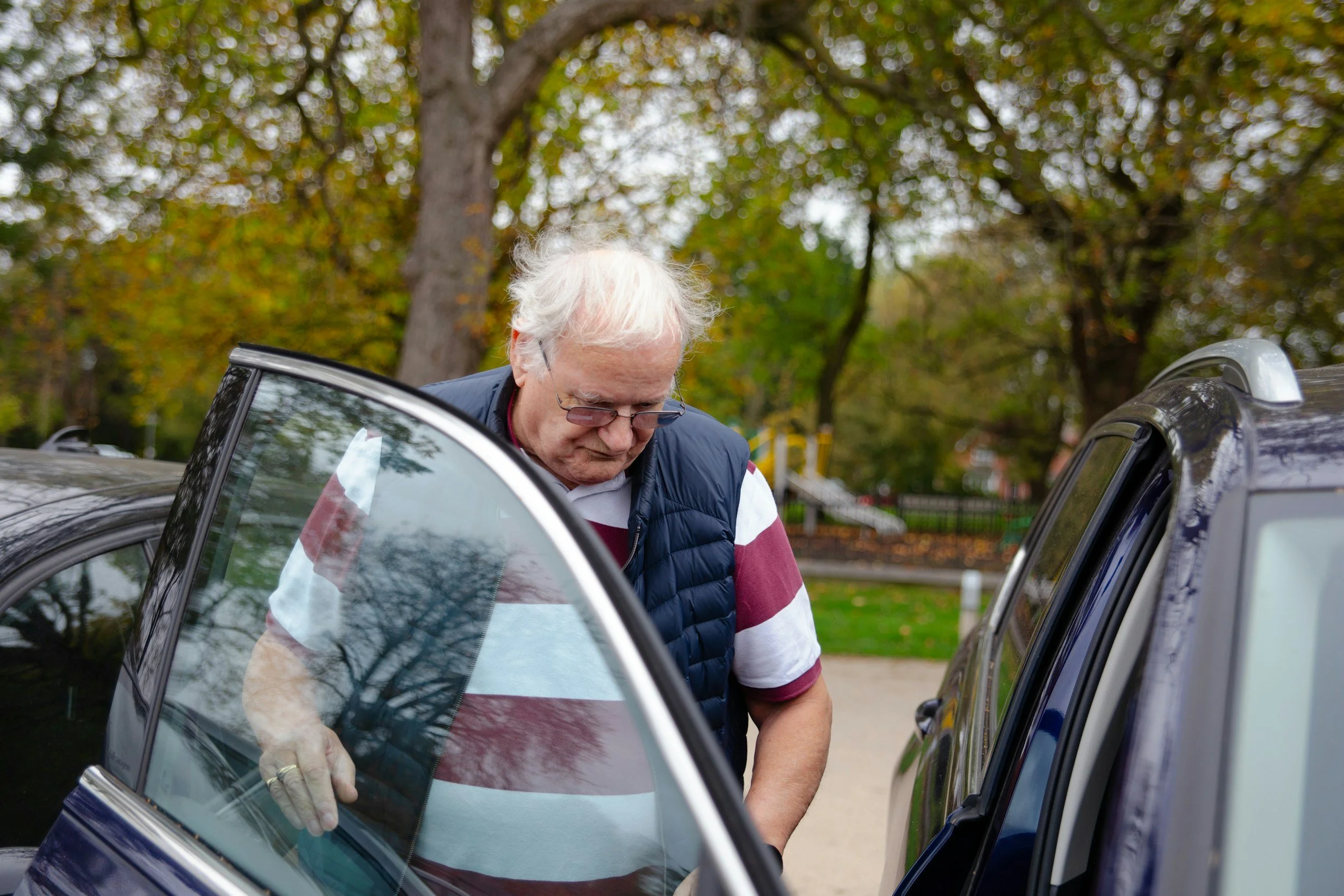 Older man stepping out of a car door during an ambulatory ride