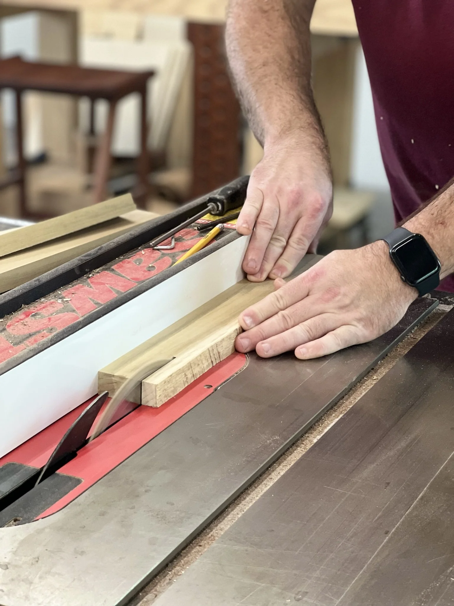 Person using a table saw to cut wood.