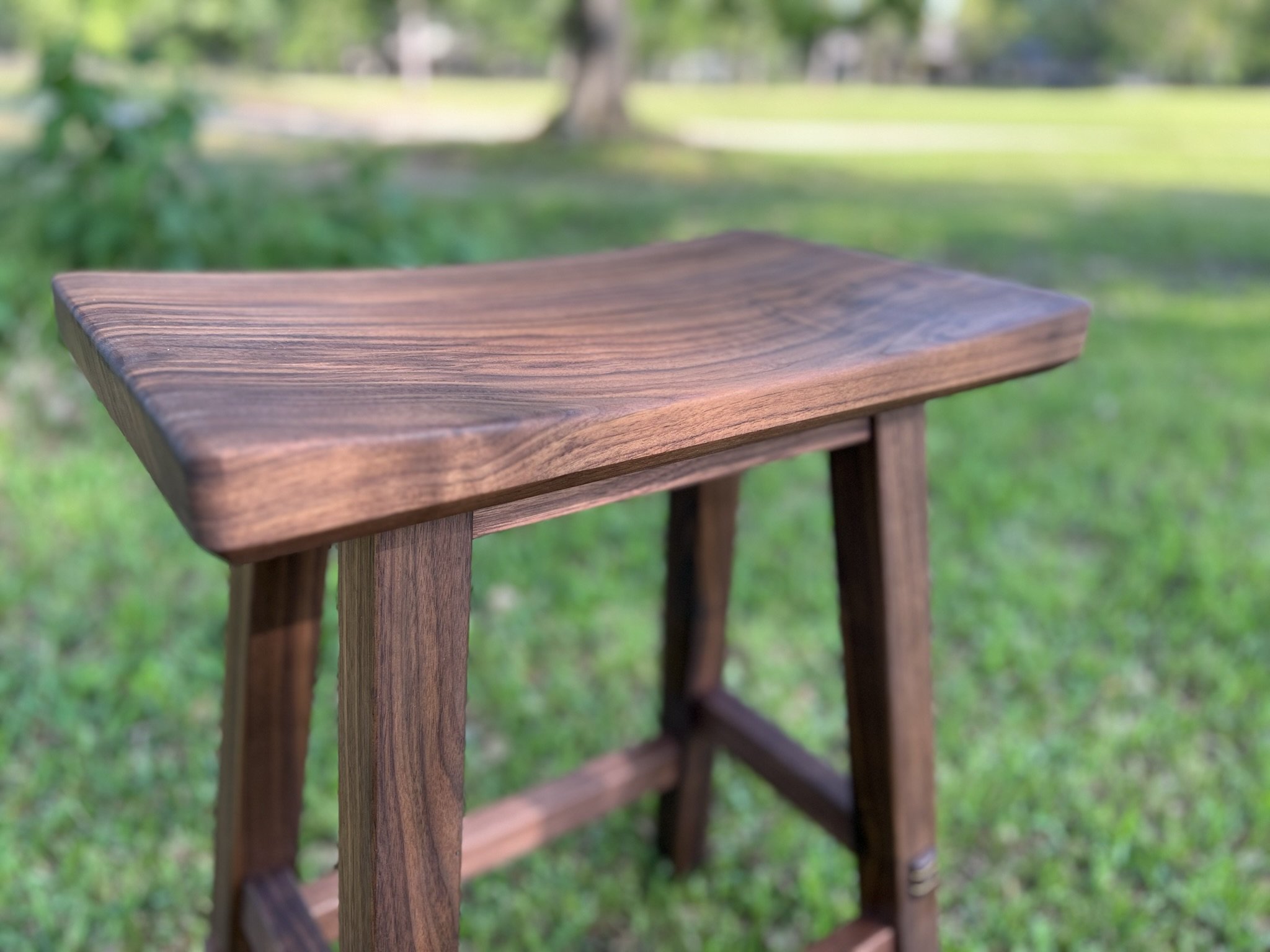 Wooden stool with curved top in outdoor setting