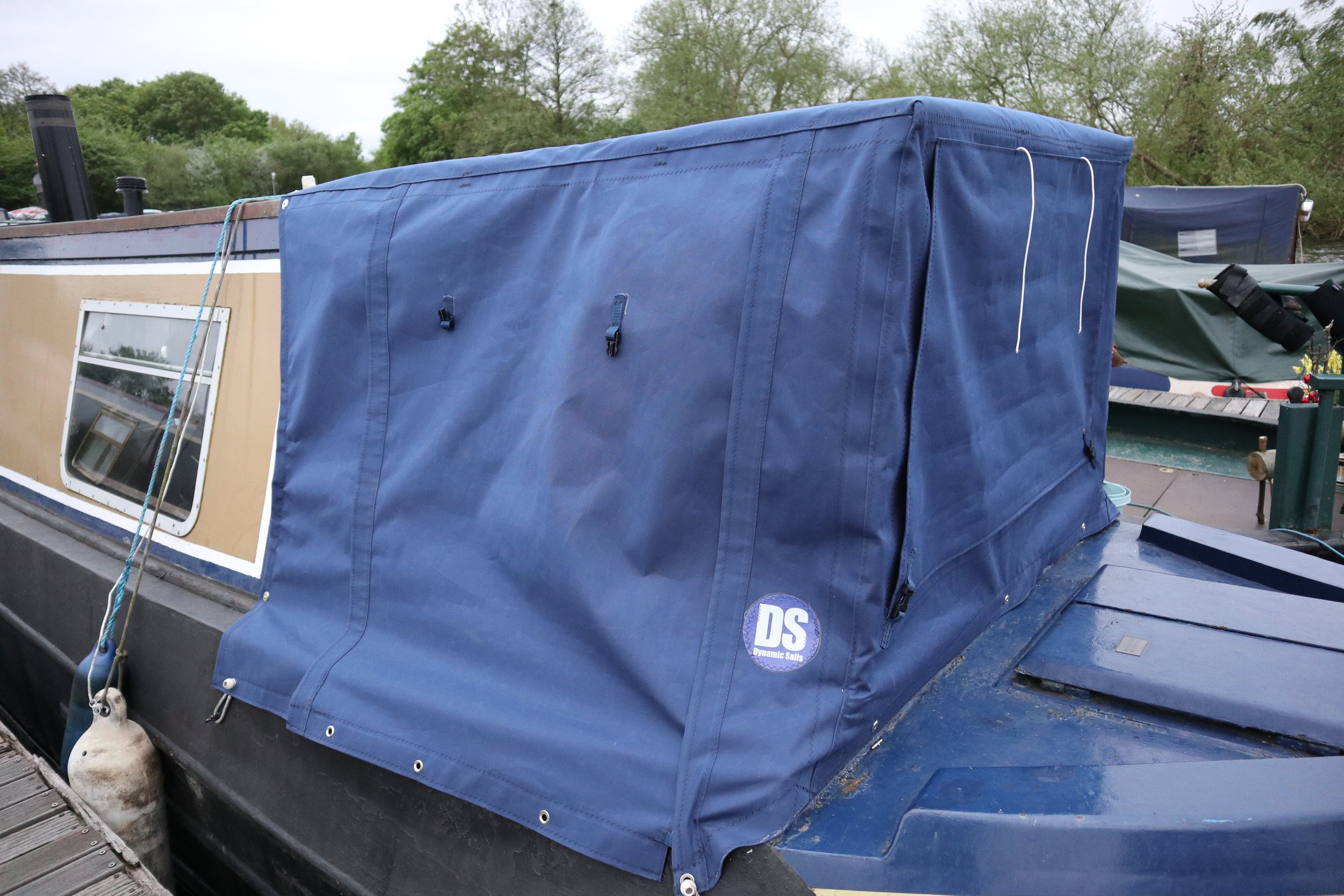 Blue canvas Cratch cover on a boat roof with a logo that reads 'DS Dynamic Sail' near the bottom edge. extra space for your river boat