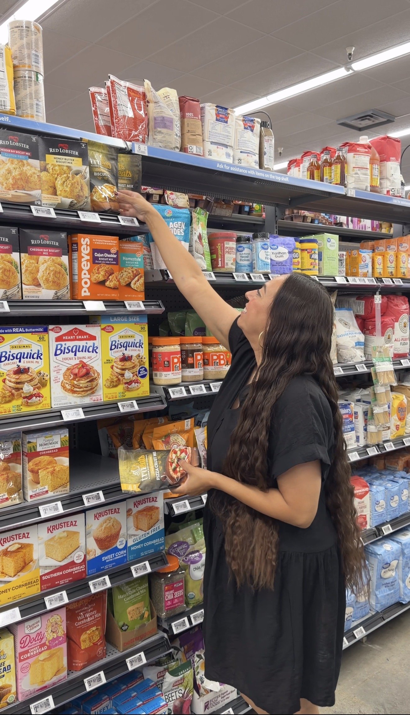 Woman shopping for TruEats gluten-free baking mixes in the Walmart baking aisle