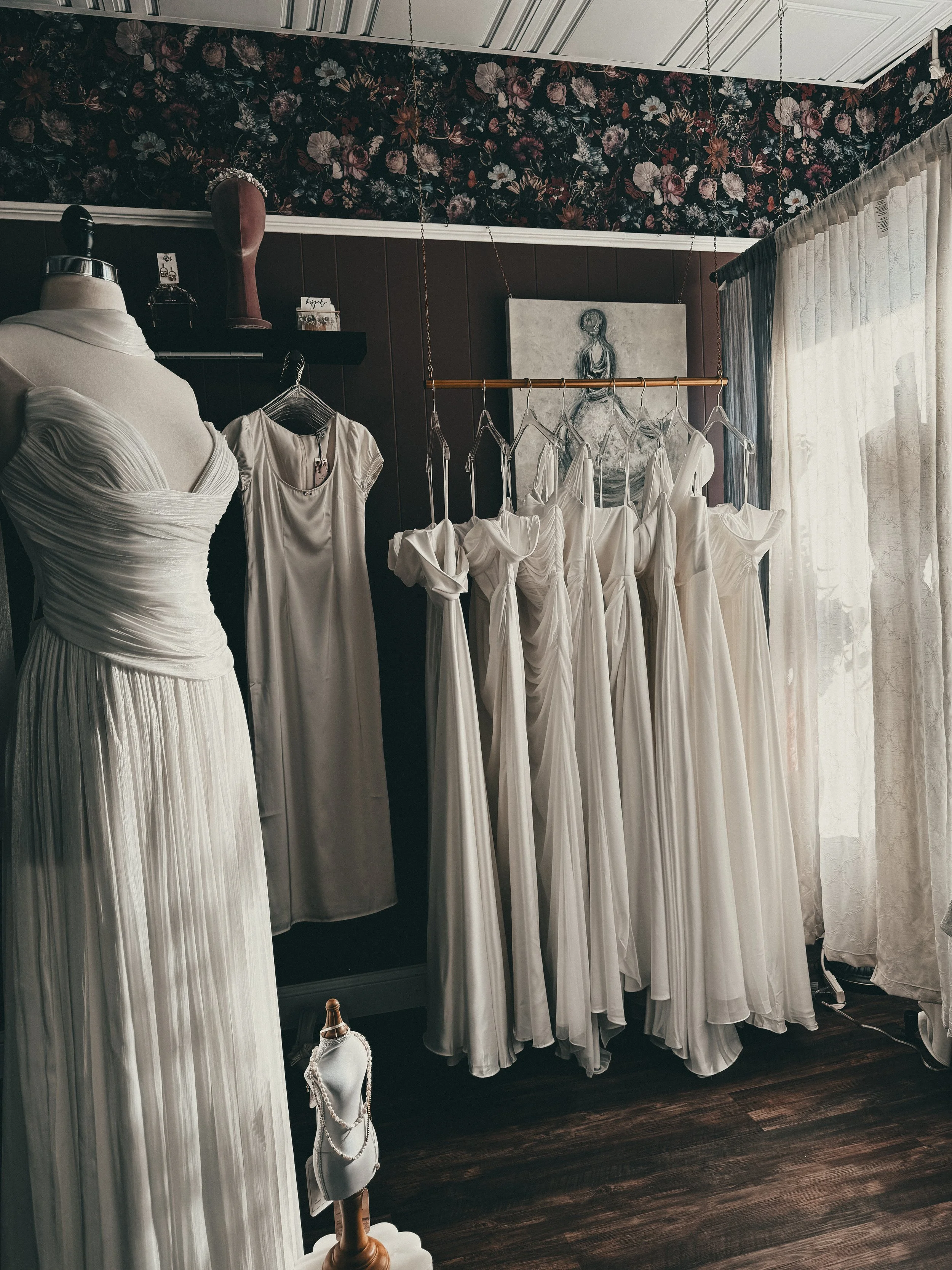 Row of minimalist slip and column wedding gowns hanging in the Modern Minimalist zone at Art & Lace Bridal.