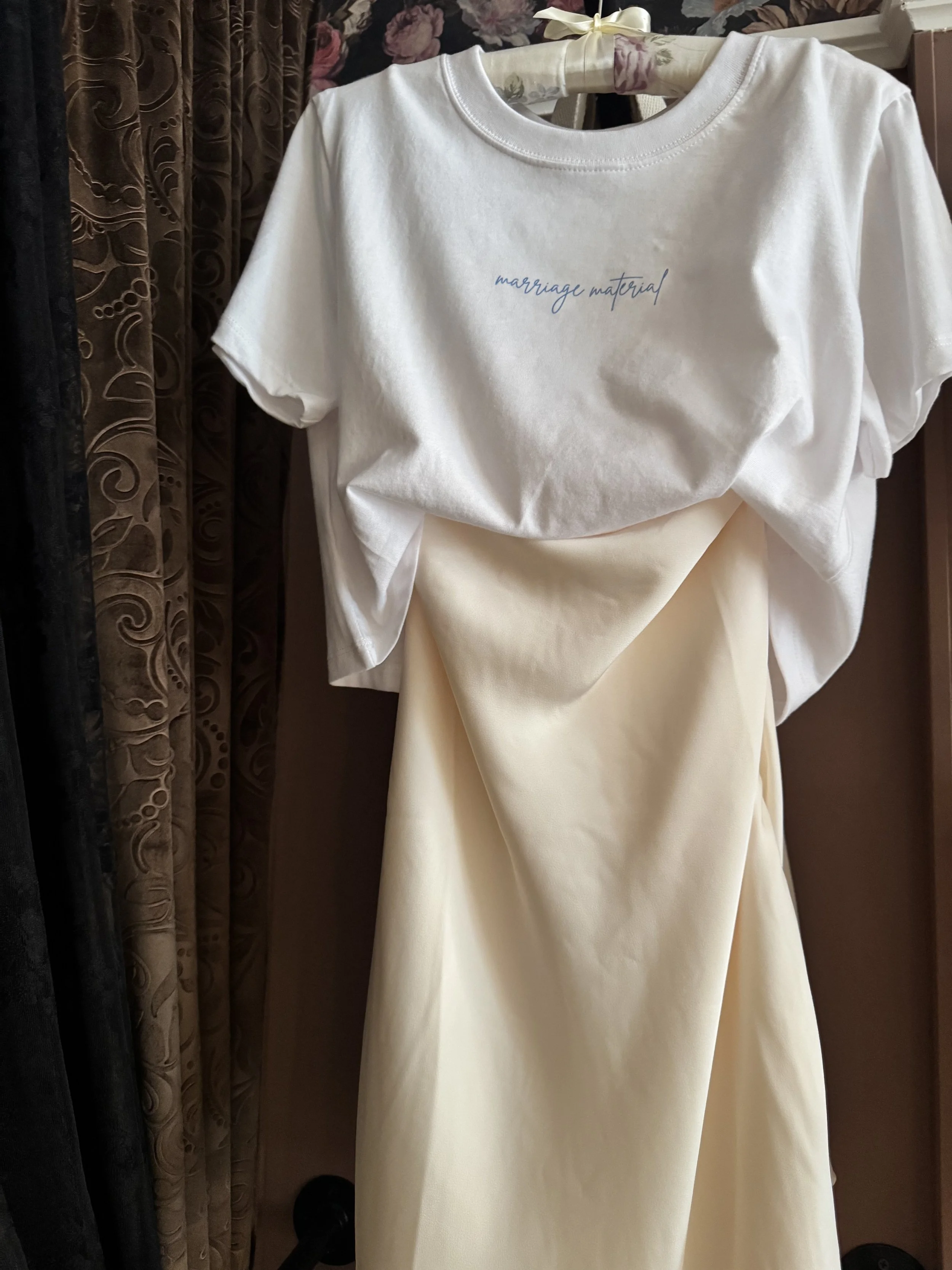Marriage Material Graphic Tee — a soft cream tee with hand-scripted "marriage material" text at the chest