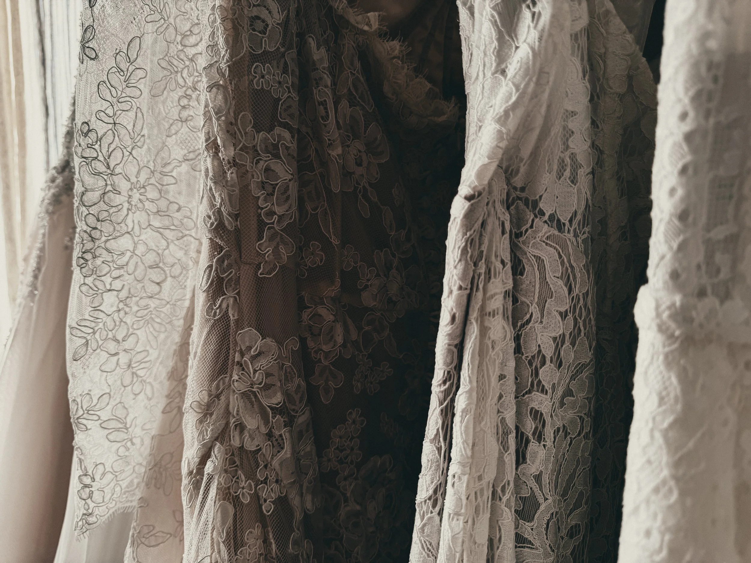 Close-up of hand-appliqué lace sleeve and satin gown at Art & Lace Bridal in Somerset, MA — Romantic Heirloom realm detail.