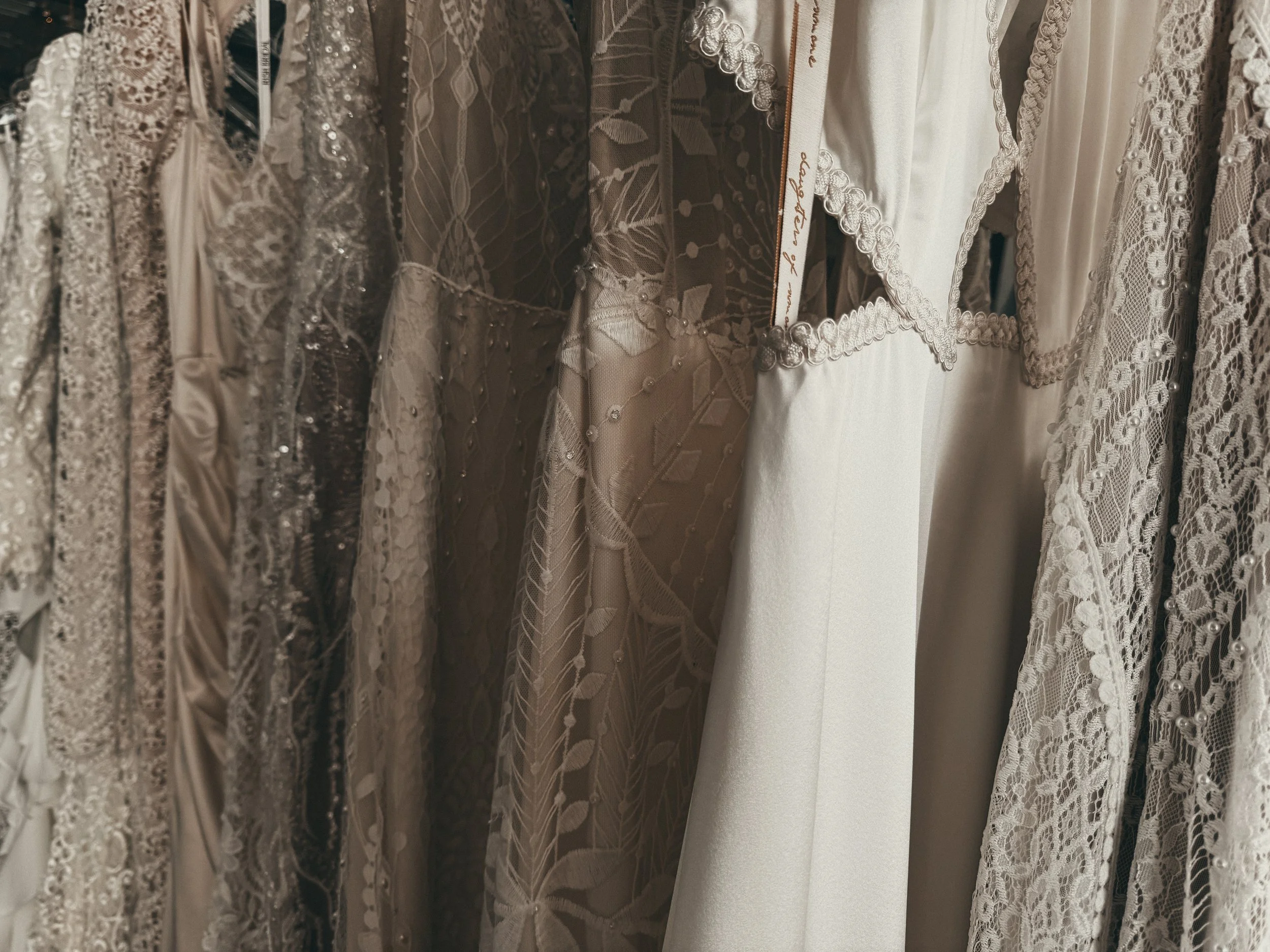 Vintage-inspired bohemian gowns in mixed lace and satin fabrics at Art & Lace Bridal in Somerset, MA.
