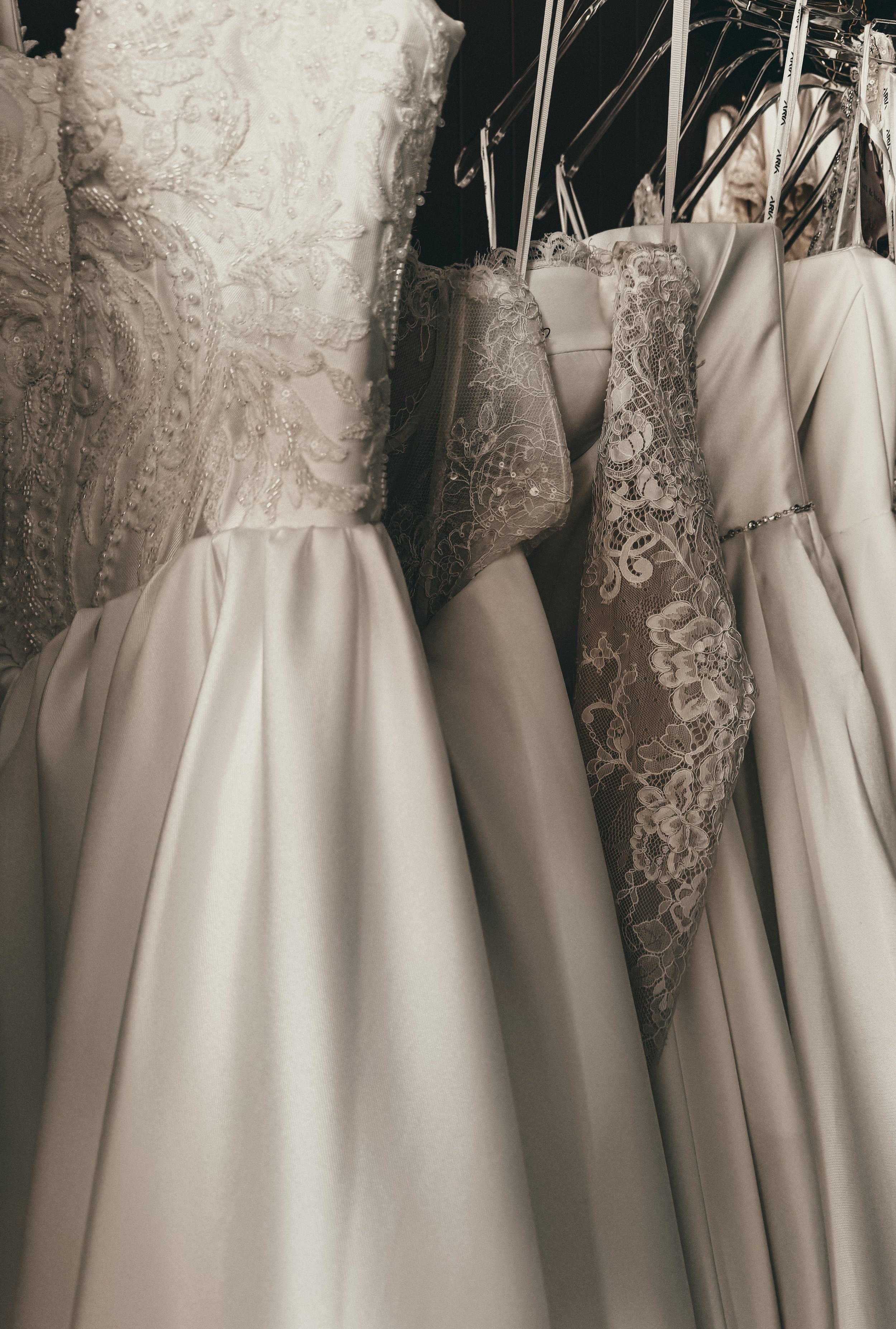 Row of refined classic wedding gowns in satin and lace at Art & Lace Bridal in Somerset, MA — timeless bridal styling.