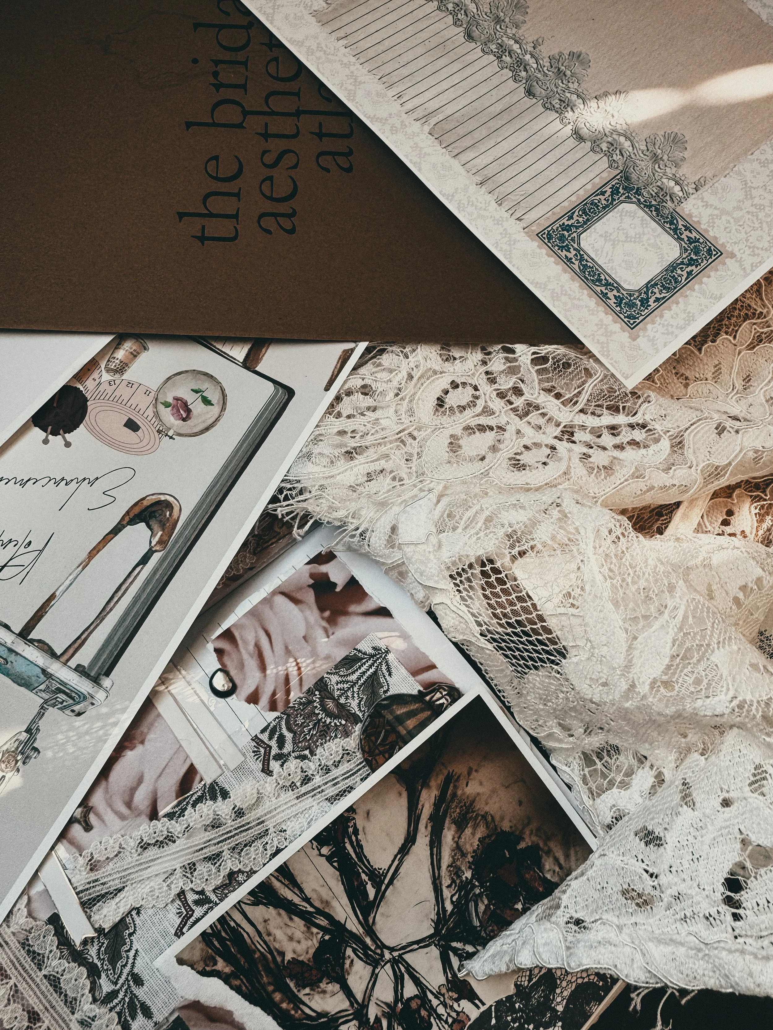 A collection of vintage lace fabric, printed photographs, and paper items on a textured surface.