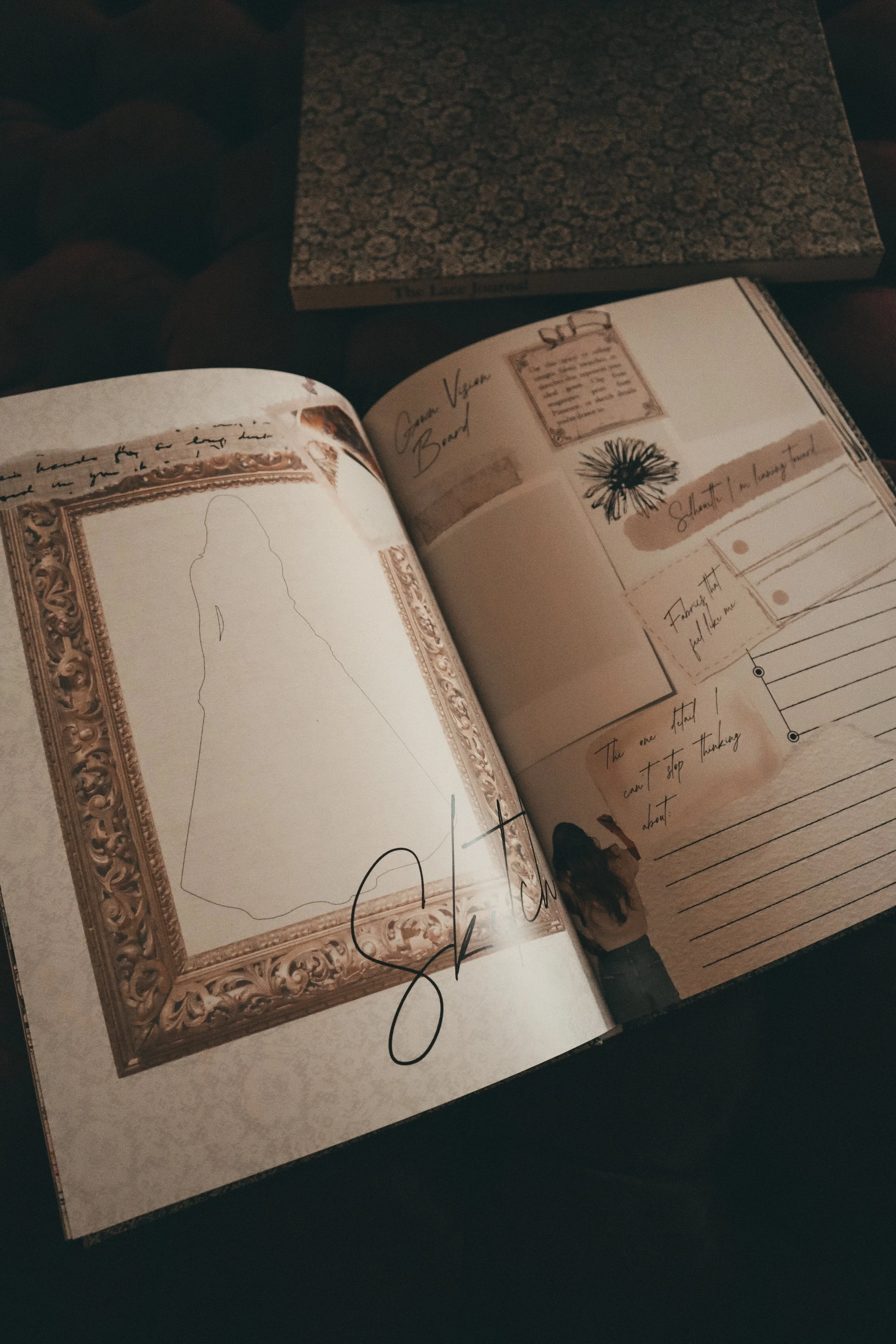 Open notebook with sketches, handwritten notes, and illustrations, including a rectangular frame with decorative borders, a hand-drawn flower, and various handwritten annotations and signatures.