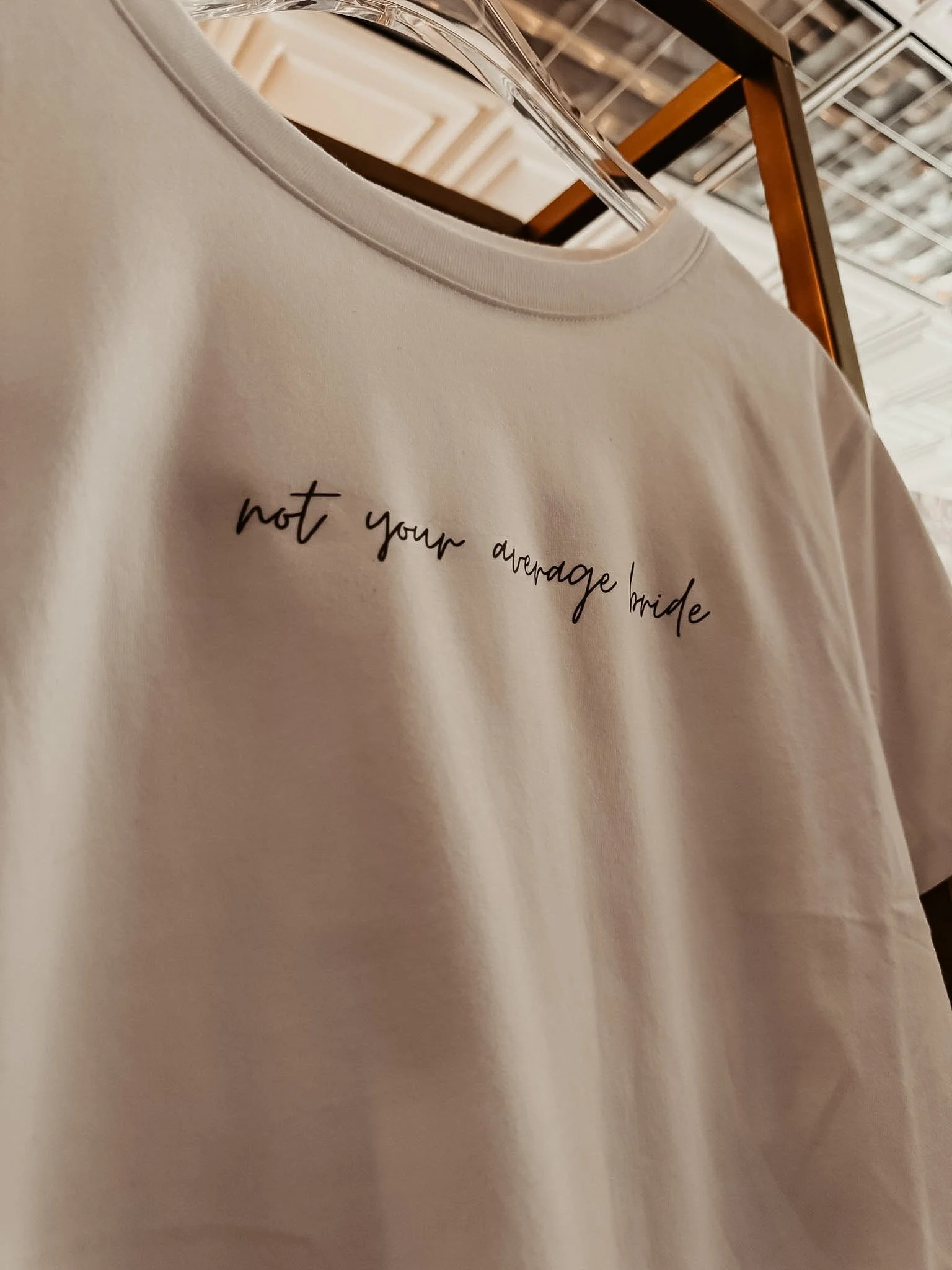 Detail of the Not Your Average Bride Tee showing the delicate cursive placement across the chest