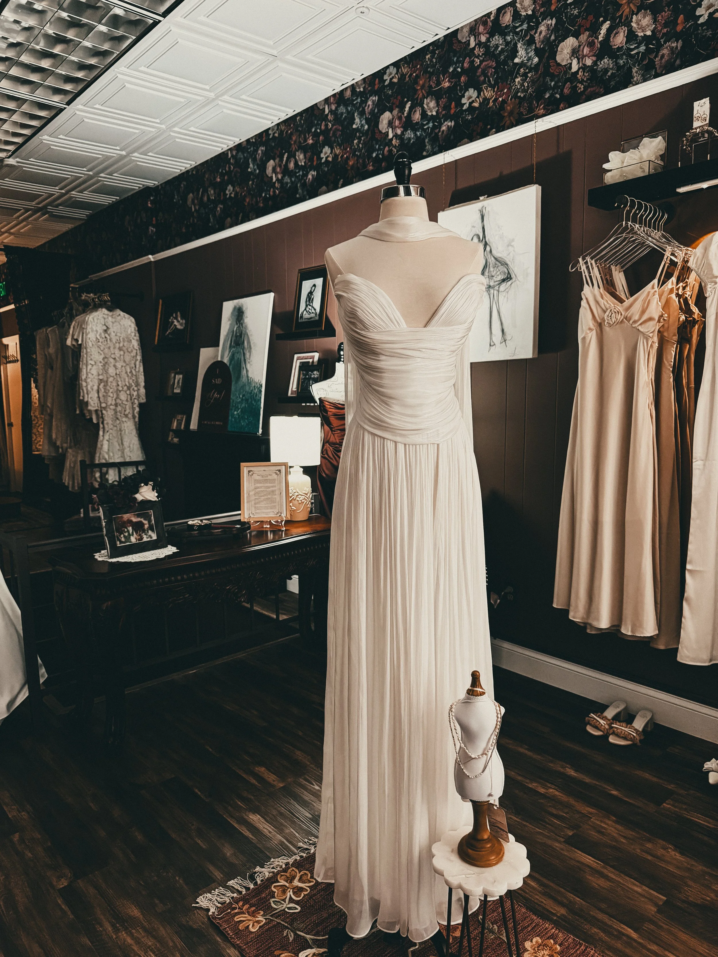 Ivory pleated bridal gown styled on a mannequin at the Art & Lace Summer Sample Sale — designer gowns 50 percent off retail in Somerset, MA.