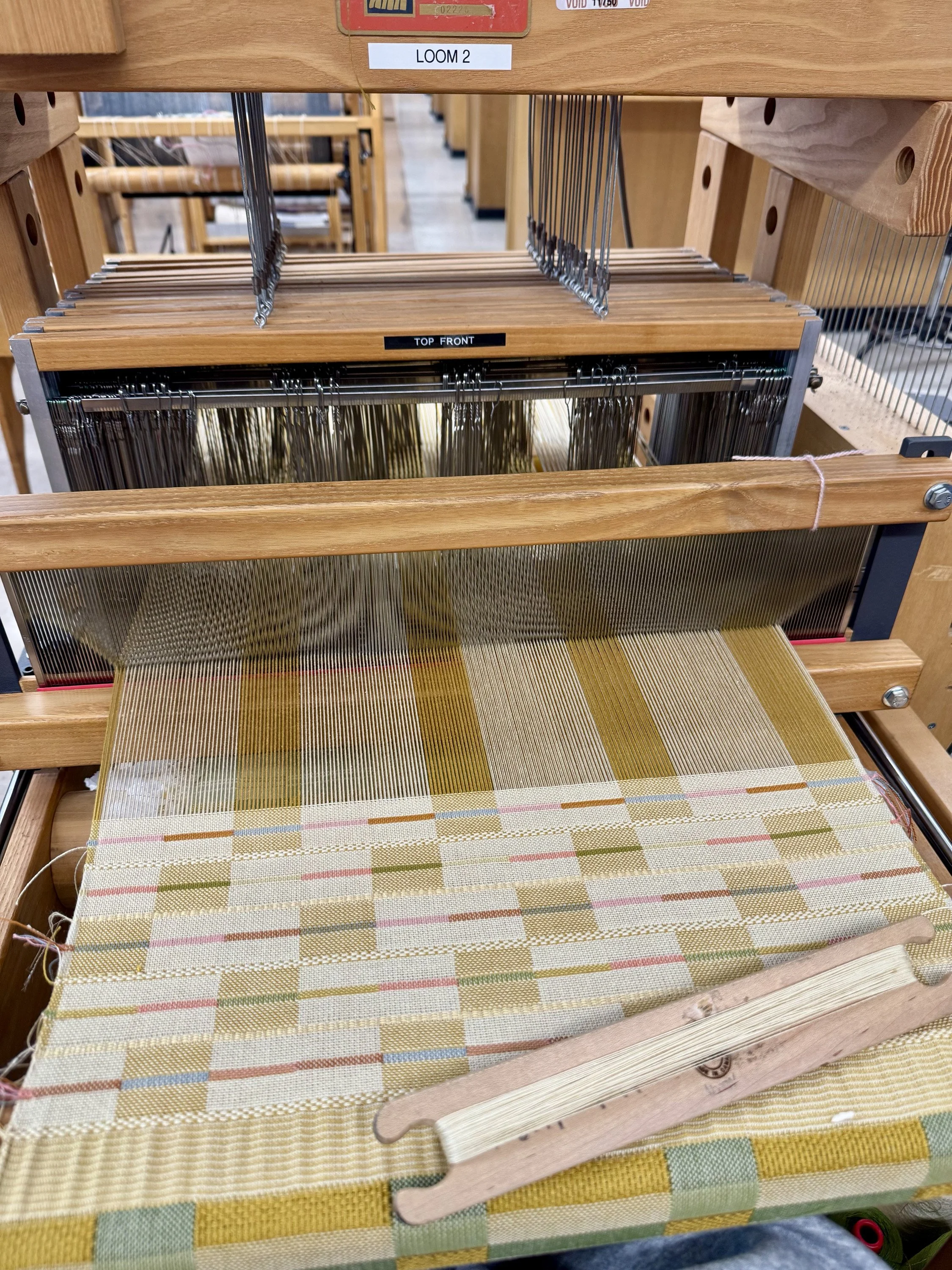 Hand weaving on computerized AVL floor loom.