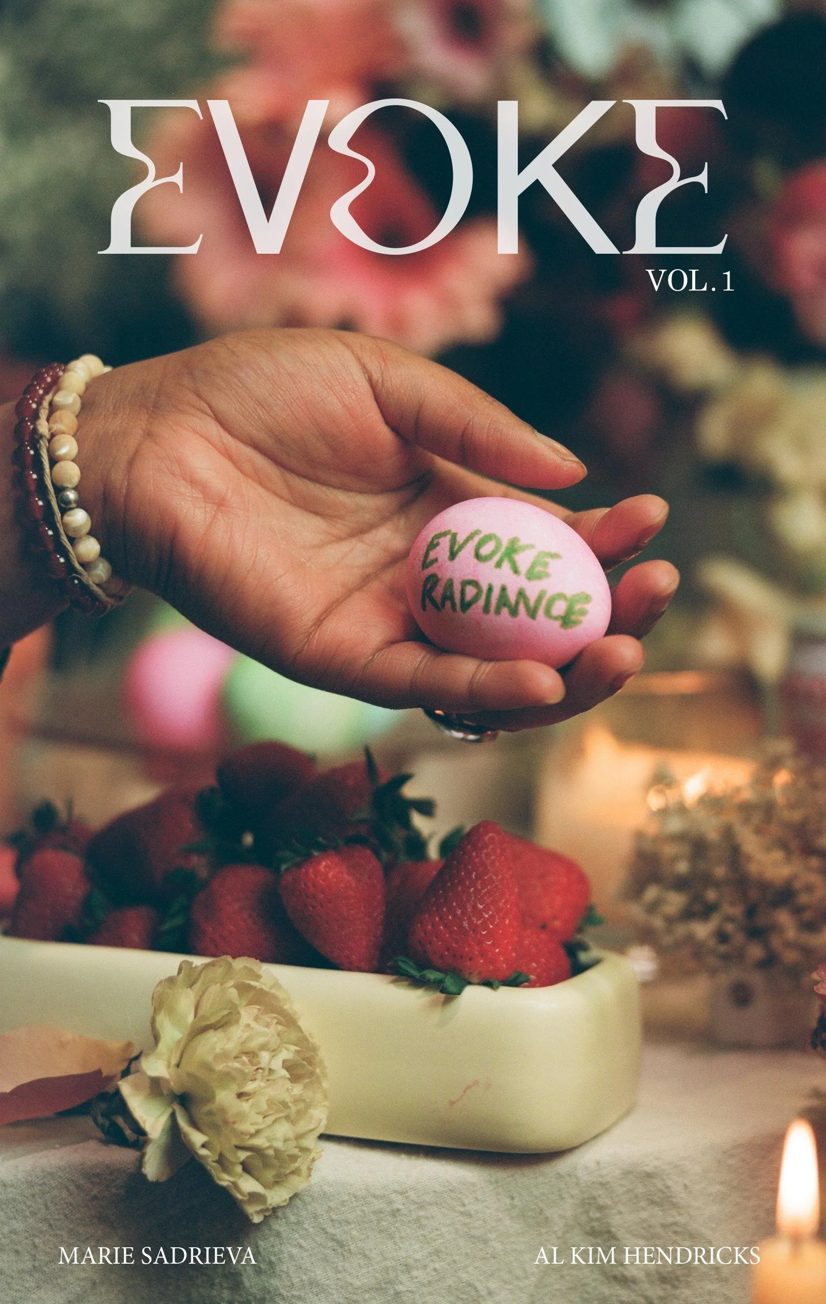 Magazine cover titled 'EVOKE VOL. 1'. The cover shows a hand holding a pink egg with the words 'EVOKE RADIANCE' written on it, and strawberries and flowers on a table in the background.