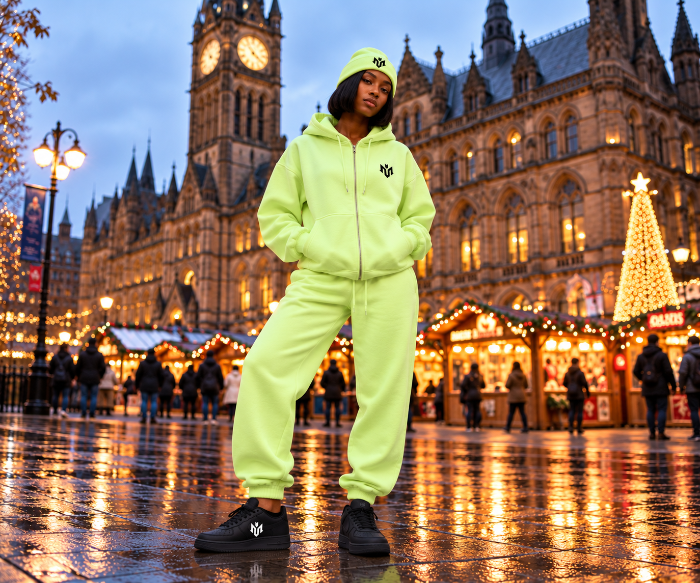 Woman wearing a lime green cuffed beanie with matching hoodie and joggers in front of Manchester Town Hall at the Christmas markets.