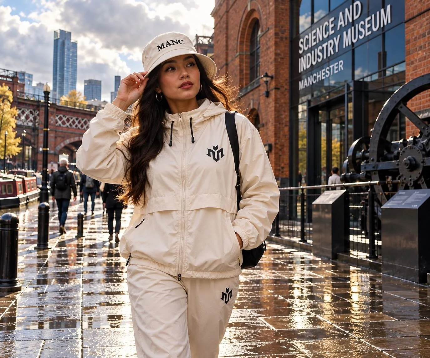 Woman wearing a windbreaker and bucket hat outside the Science and Industry Museum in Manchester on an overcast day.
