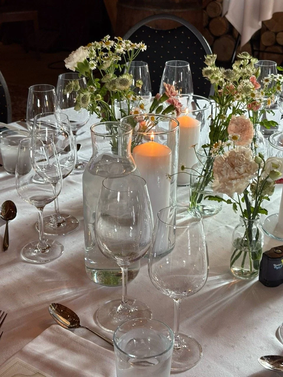 Elegant gutt bord dekorer med blomsterbuketter, lysende lyslykter og glass, klar til middag.