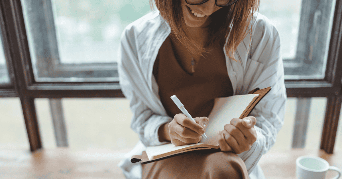 woman taking notes on website messaging with a coffee by her side