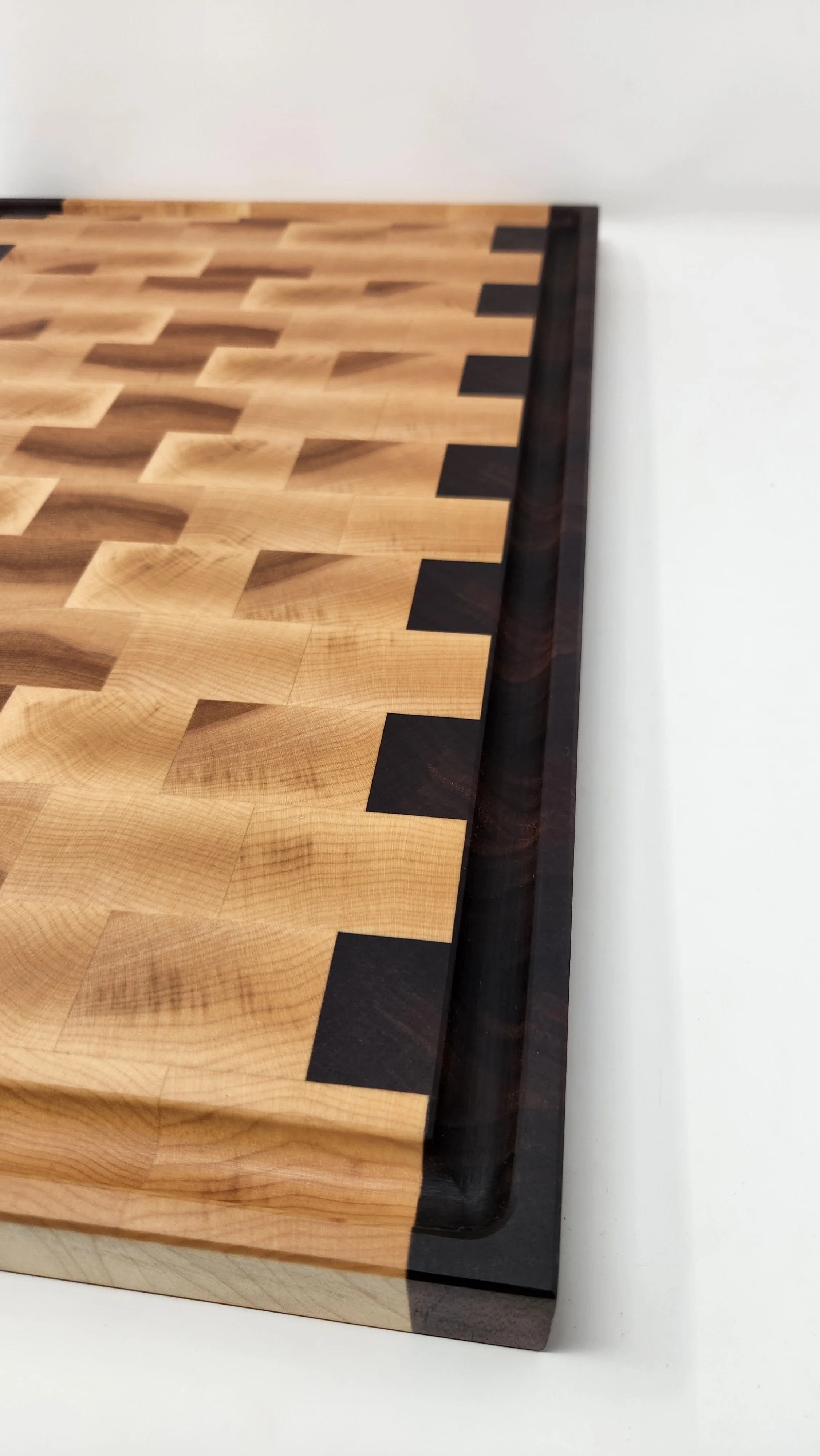 Close-up of maple and walnut end grain cutting board showing detailed checkerboard pattern