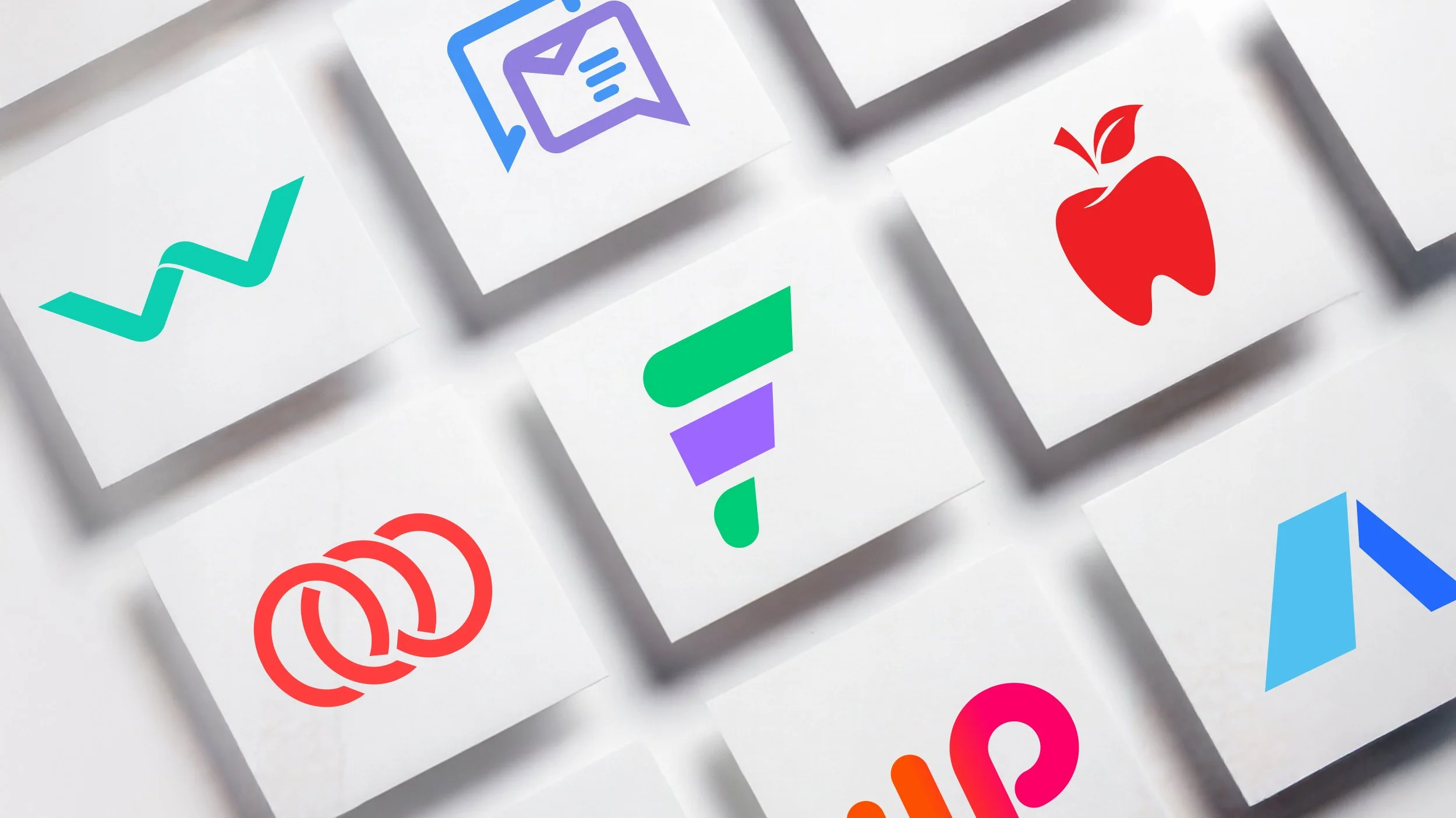 Grid of white tiles displaying various colorful modern logos, including abstract shapes, chat icon, apple symbol, interlocking loops, and geometric marks on a soft gray background.
