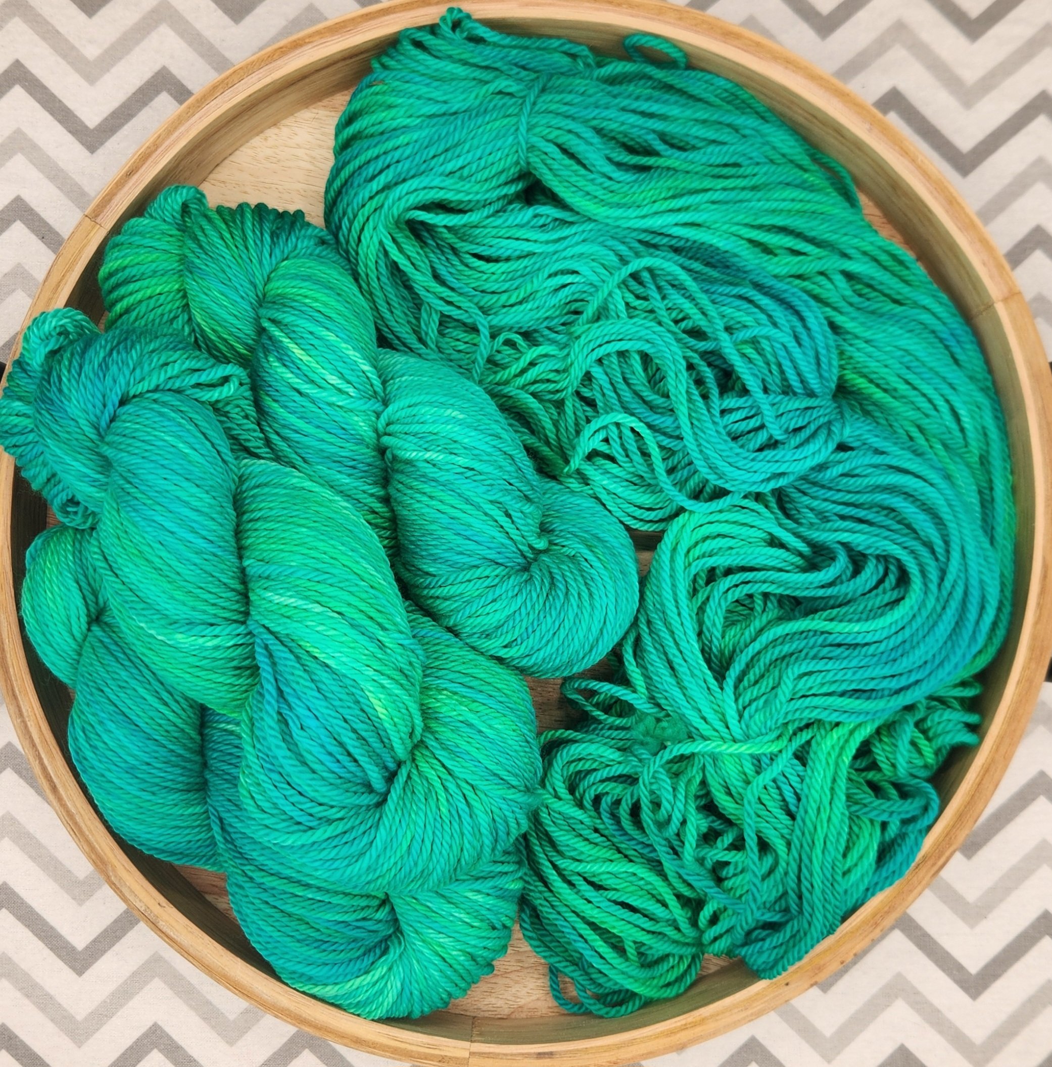 Several skeins of turquoise and green, black-light reactive, hand-dyed wool yarn.