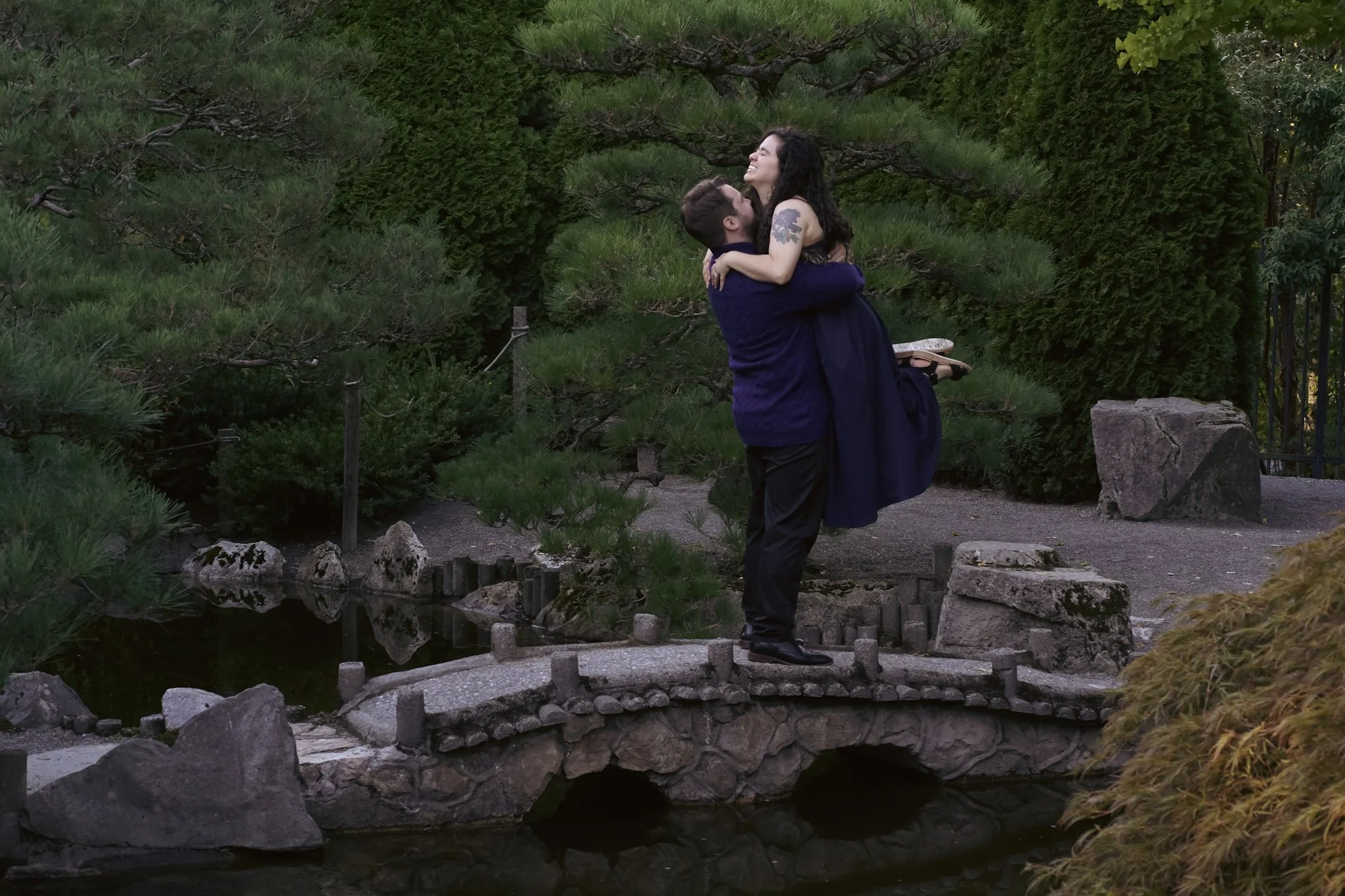 Couple posing on bridge in Japanese garden in SeaTac, WA.