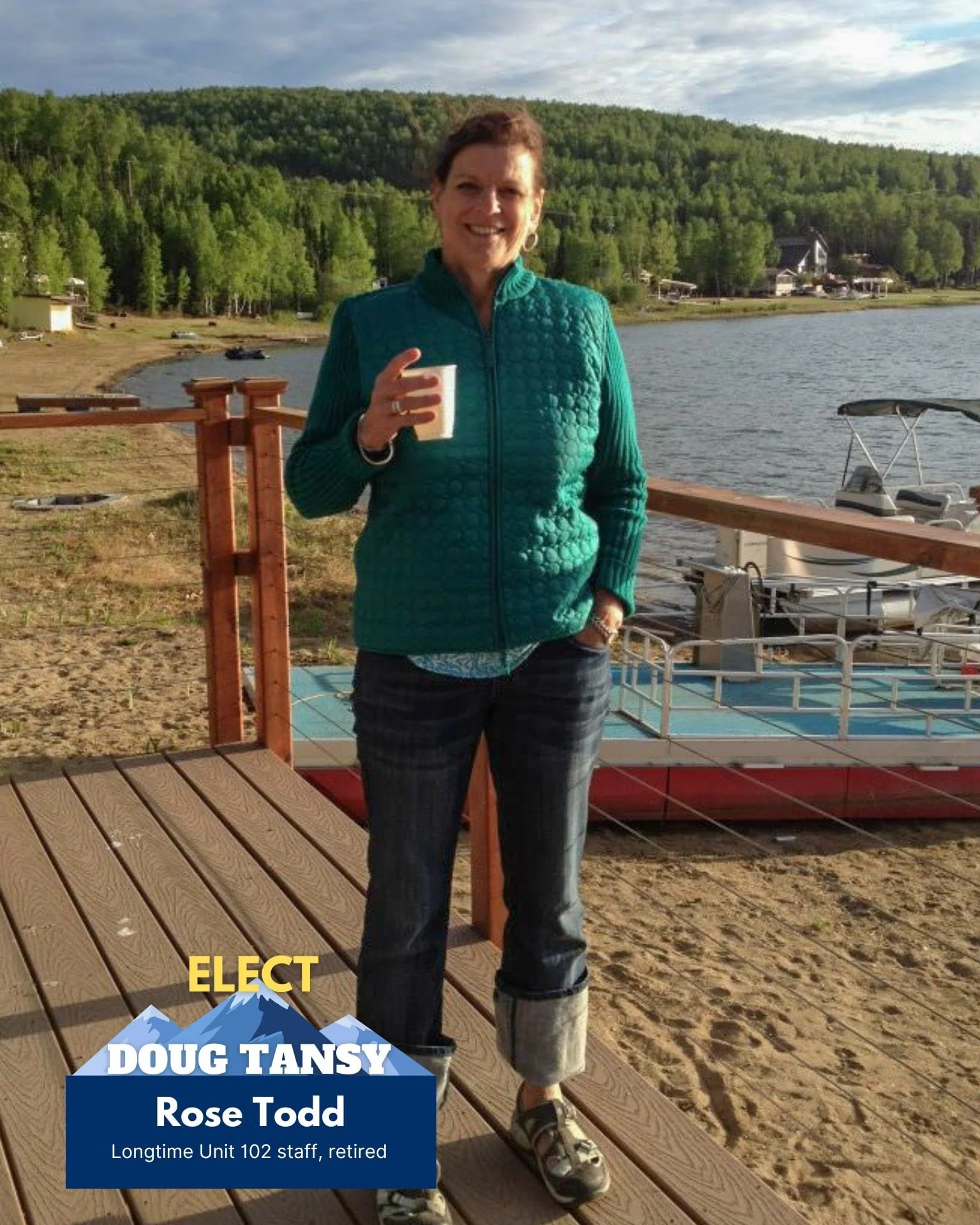 A woman standing on a wooden dock by a lake, holding a cup, with a boat in the background, green trees and hills, and a cloudy sky.
