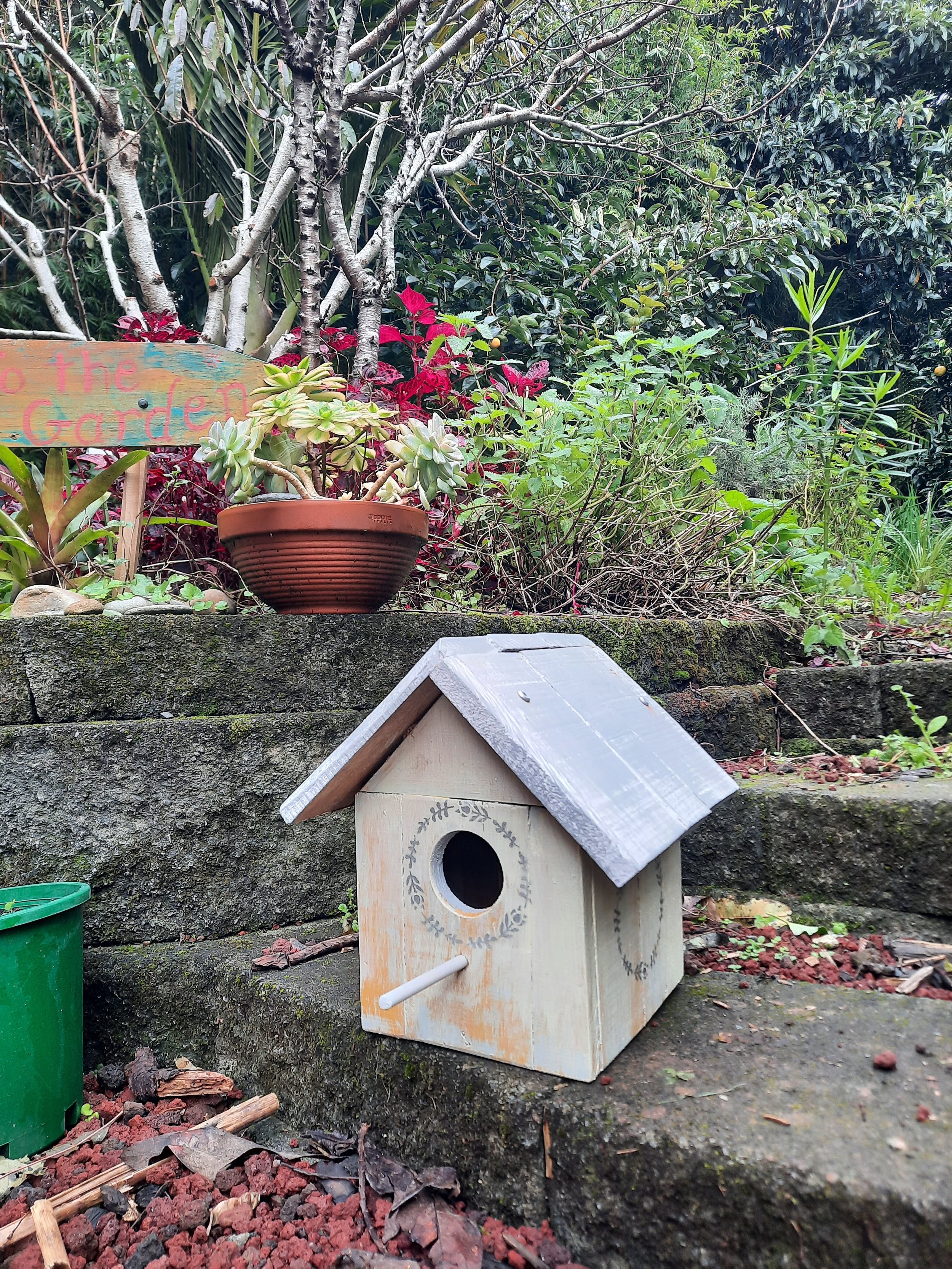 This pastel colour washed birdhouse has a stencil design in silver.