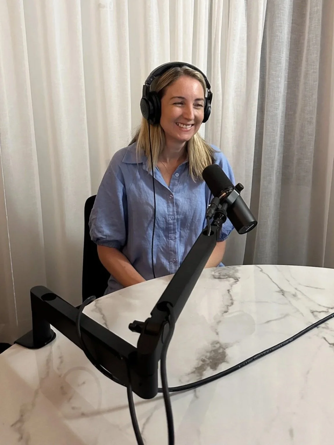 Woman - Minnie Collins - with headphones on during podcast