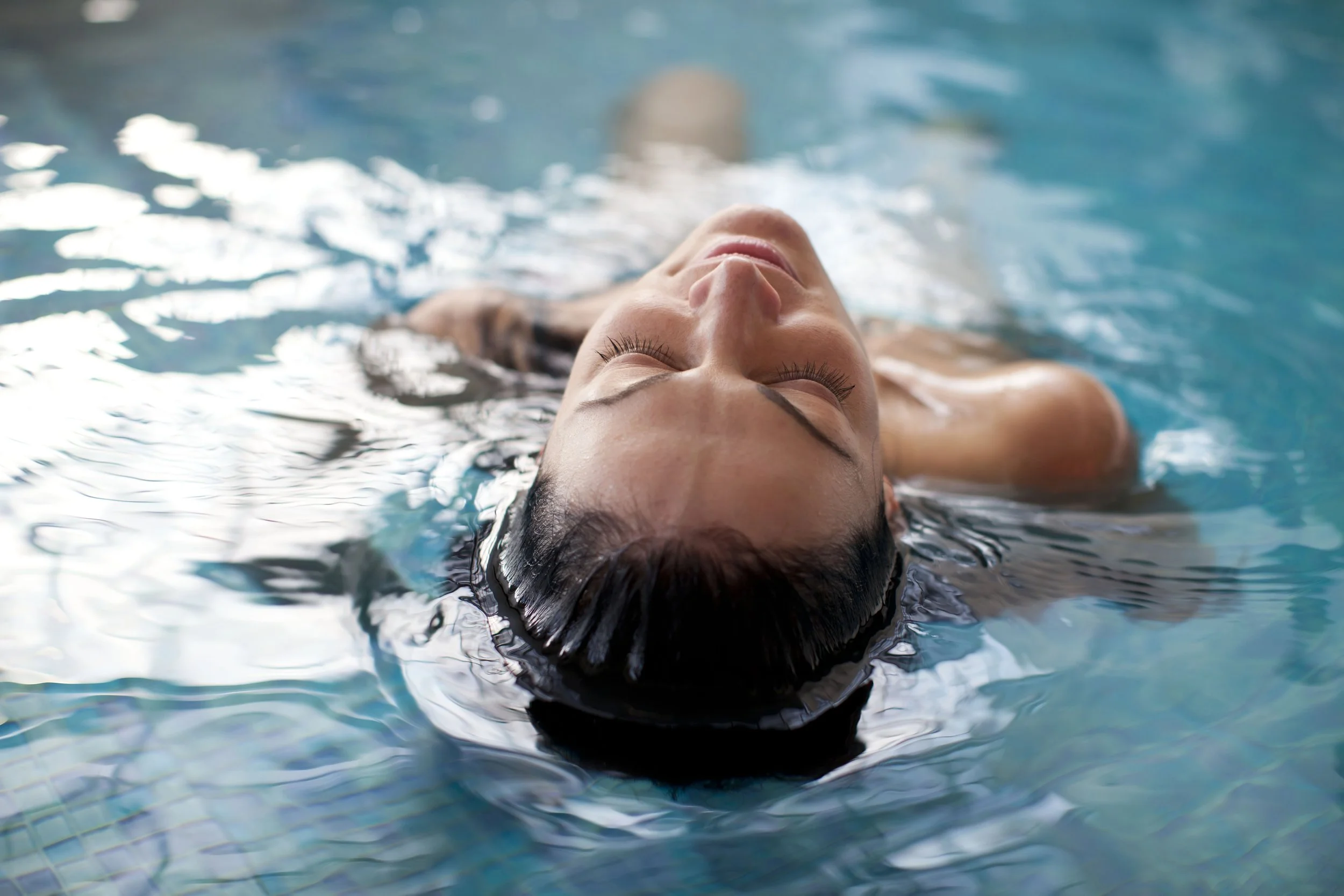 Woman floating on back in community pool