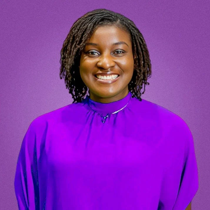 A black woman wearing a purple blouse