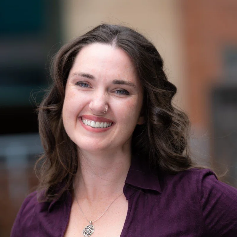 A caucasian woman wearing a purple shirt